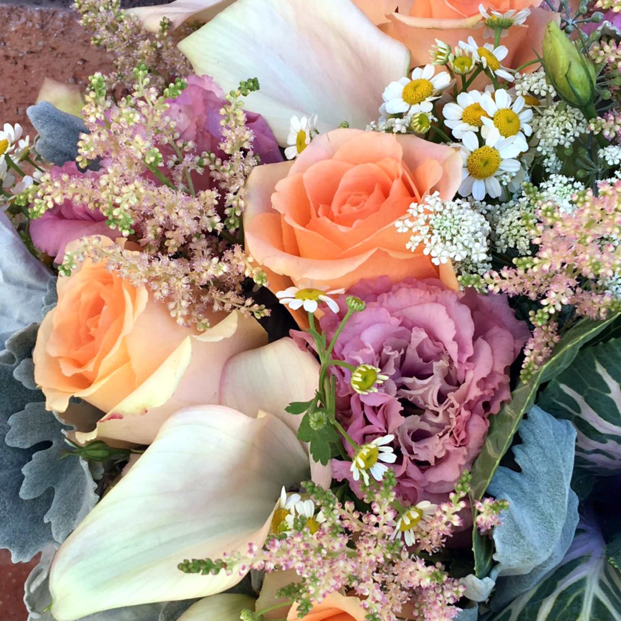 Bouquet of peach roses, white calla lilies, and small white daisies