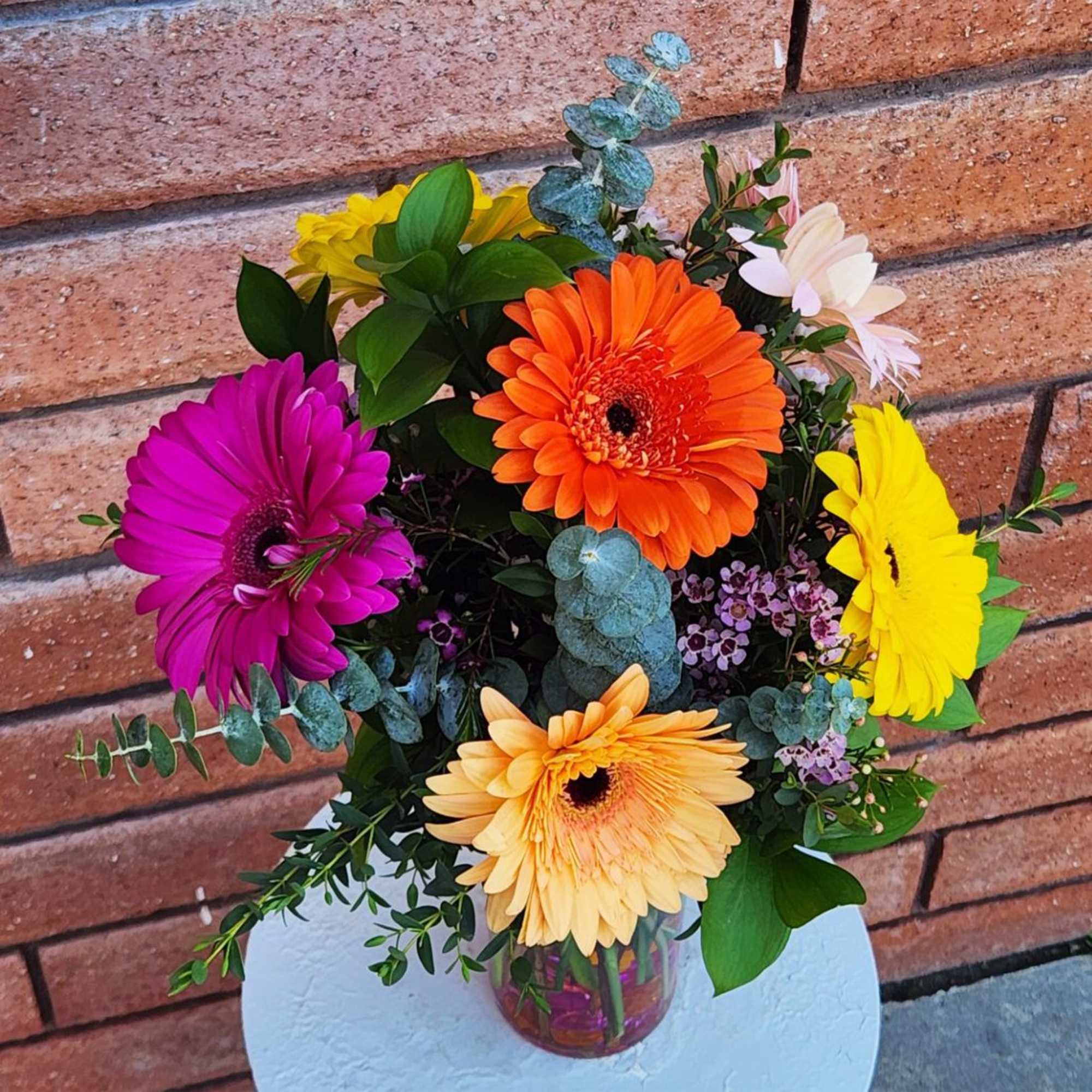 Bright bouquet of mixed gerbera daisies in a clear glass vase