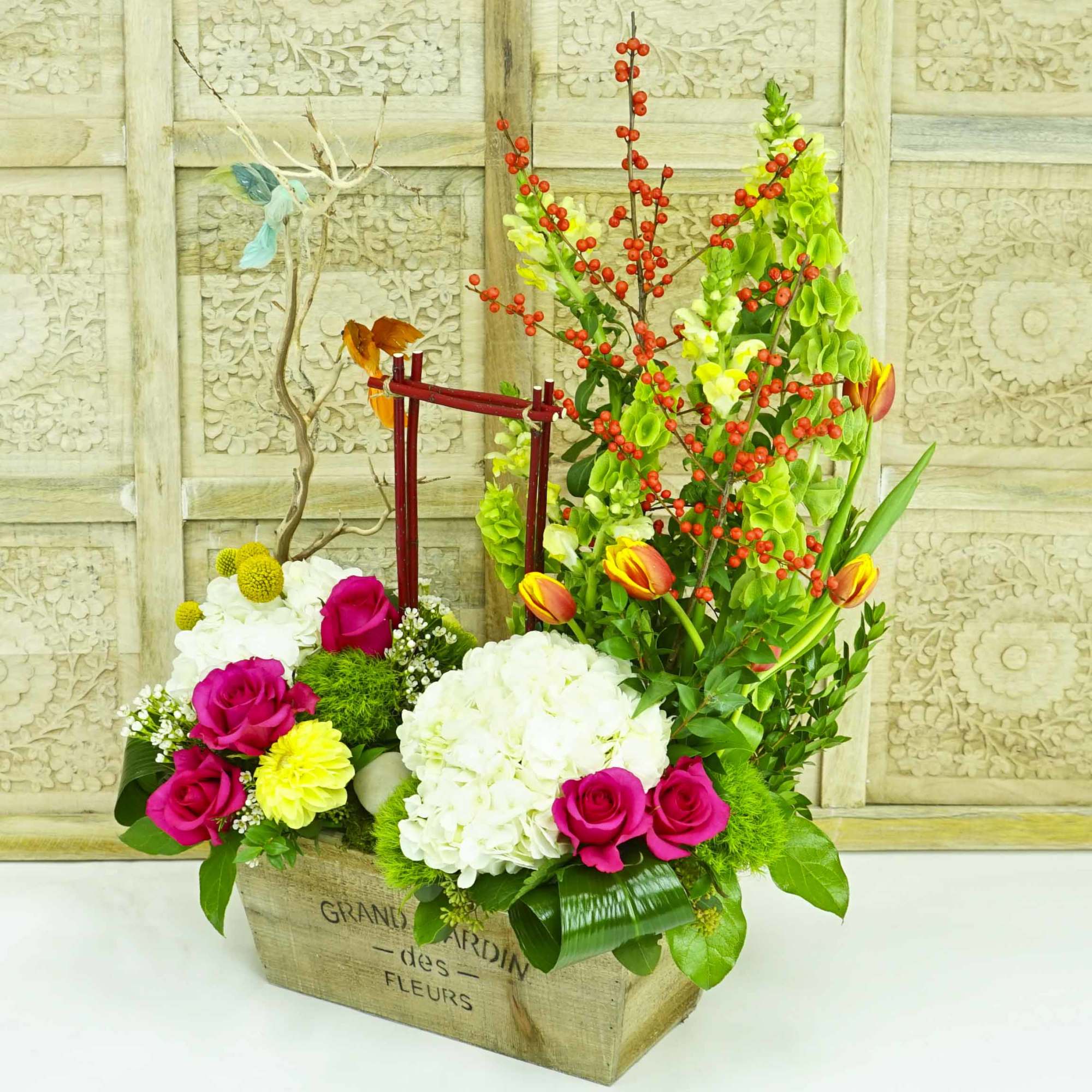 Mixed floral arrangement in a wooden box with pink roses and white hydrangeas