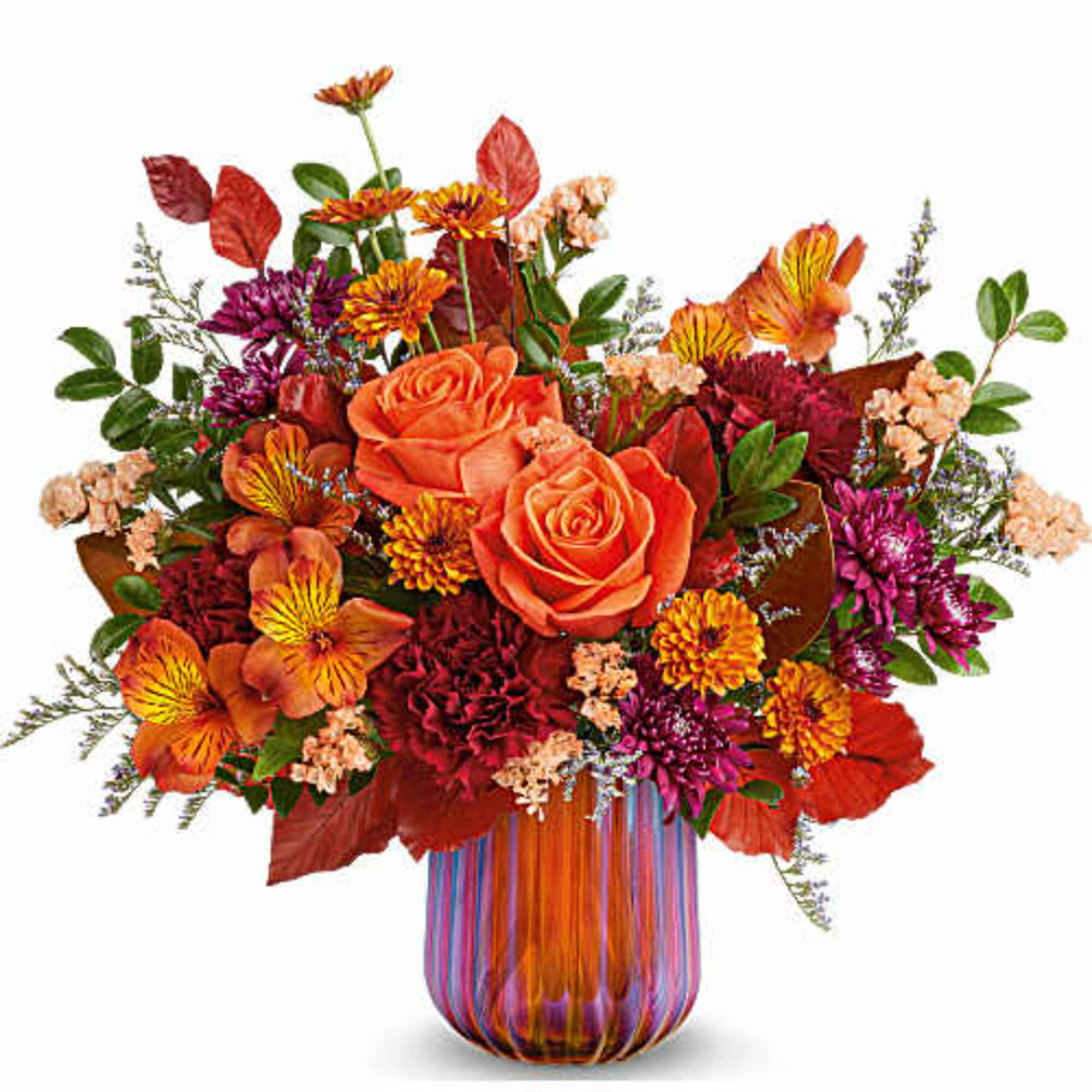 Orange roses and mixed fall flowers in a striped glass vase