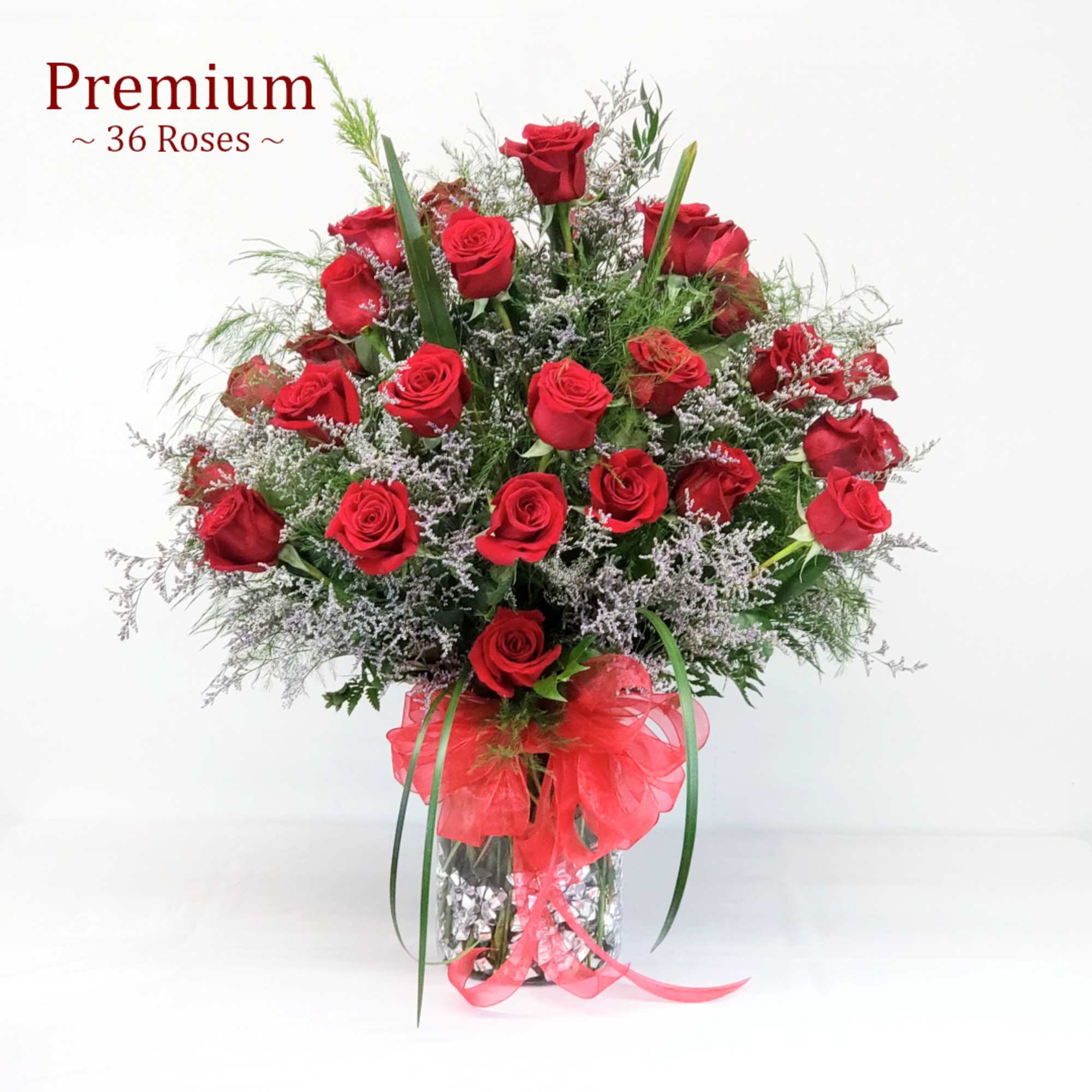 Bouquet of red roses in a clear glass vase with a red ribbon