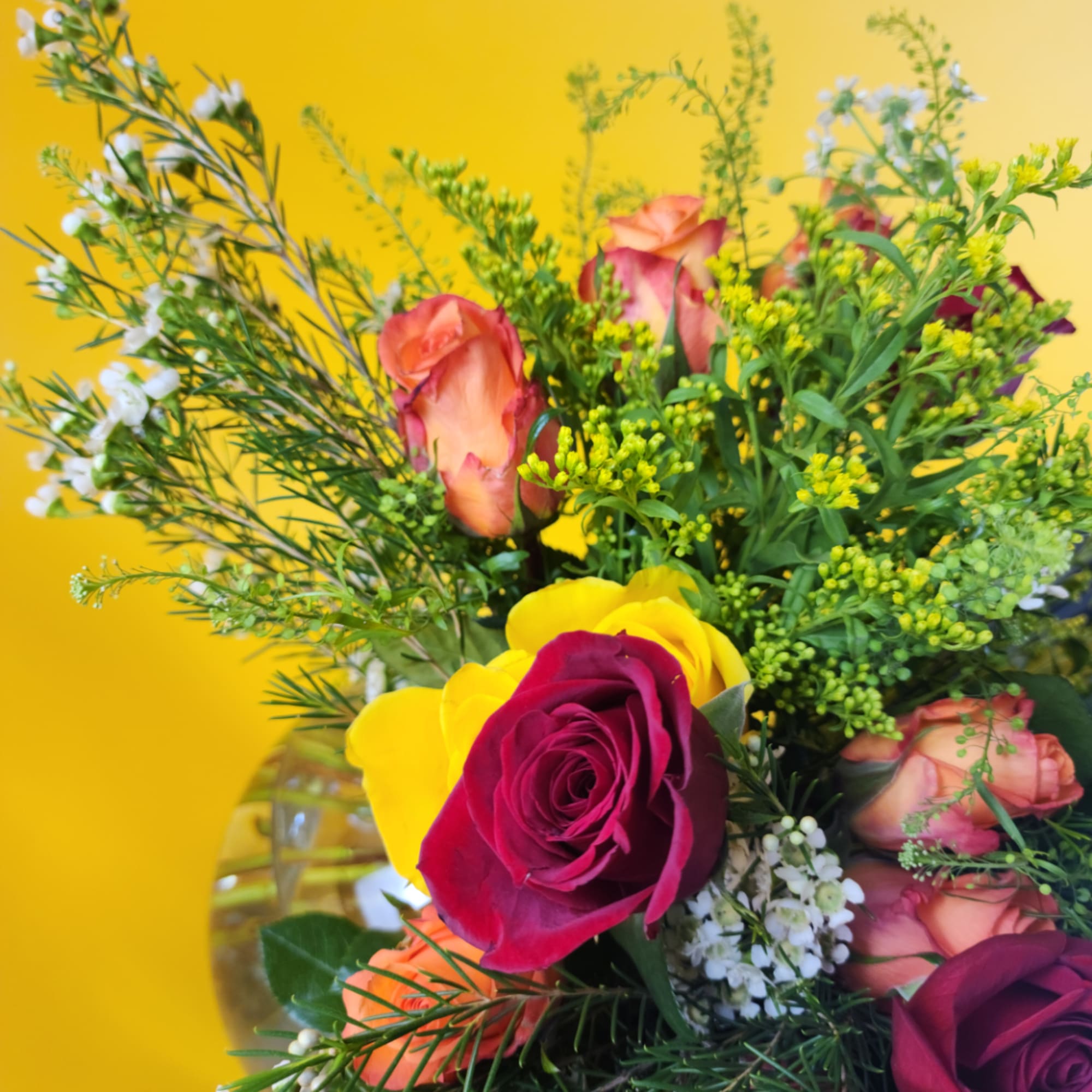 Bouquet of multicolored roses with small white filler flowers