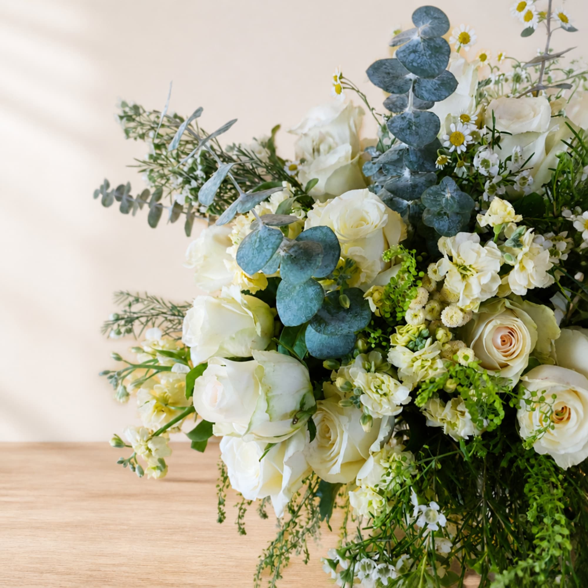 White rose bouquet with small white filler flowers and blue eucalyptus