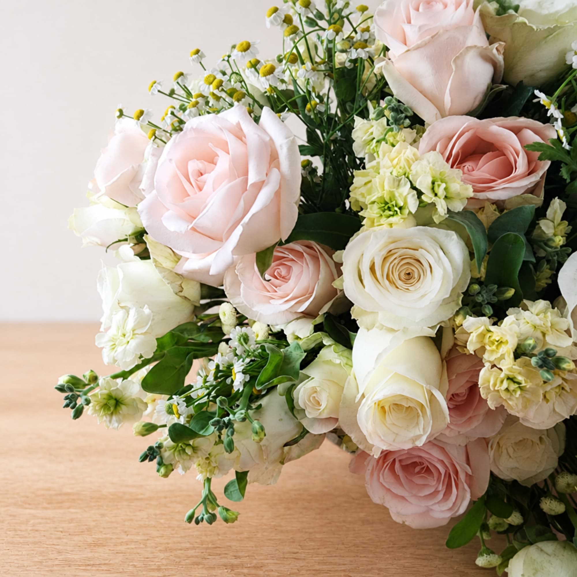 Bouquet of pale pink and white roses with small white filler flowers