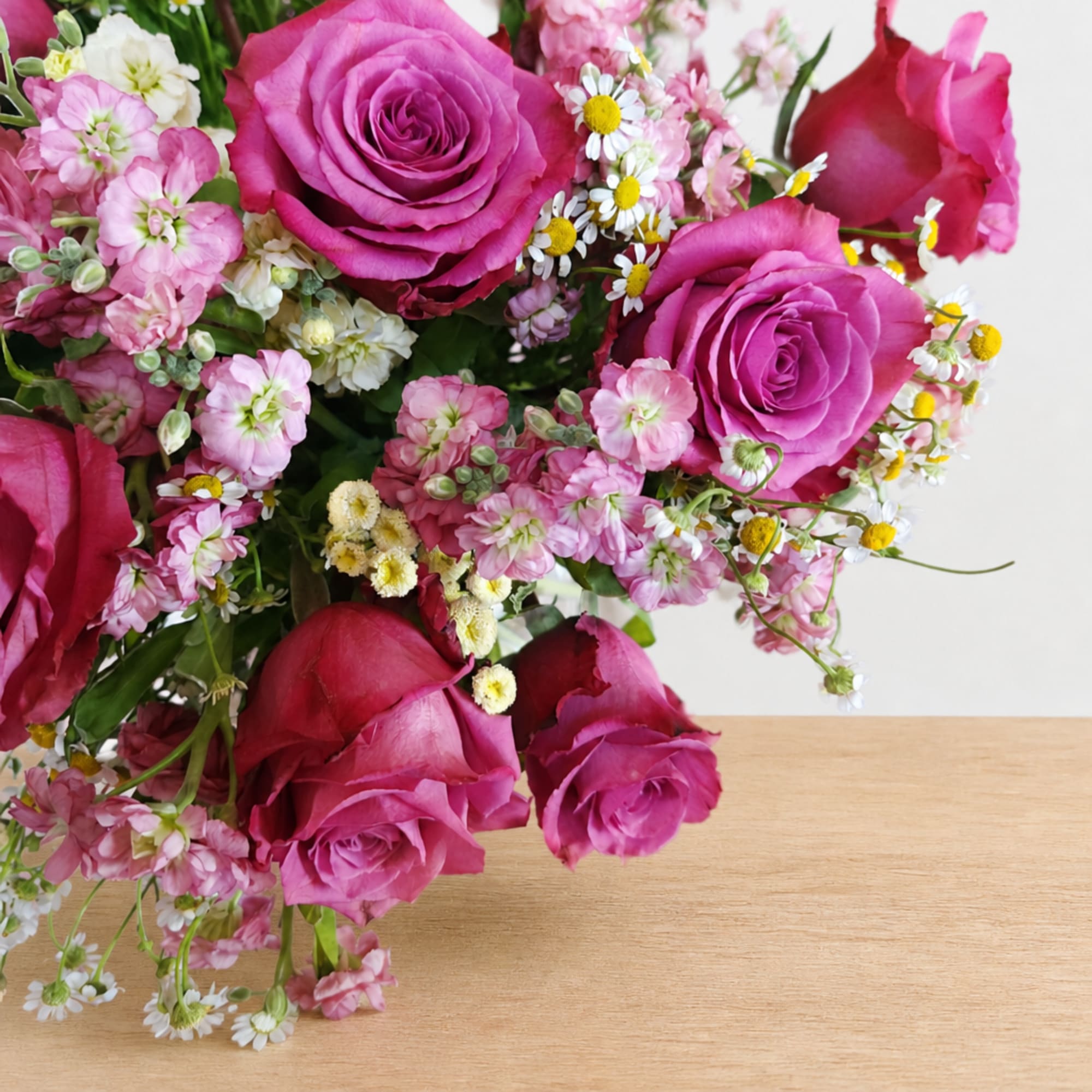 Bouquet of magenta roses with small pink and white filler flowers