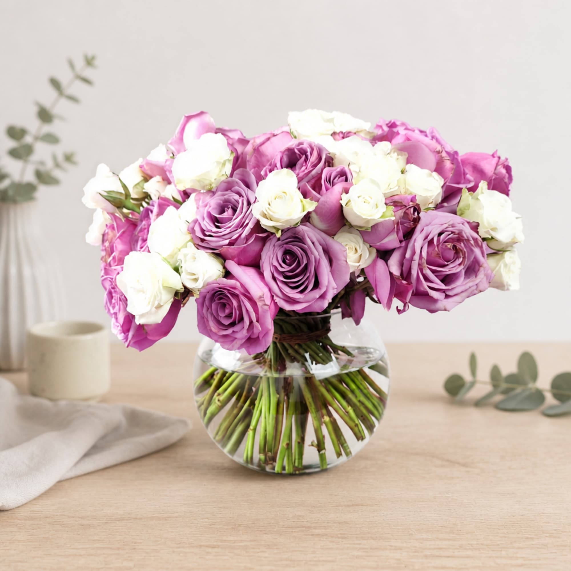 Pink and white roses arranged in a clear glass vase