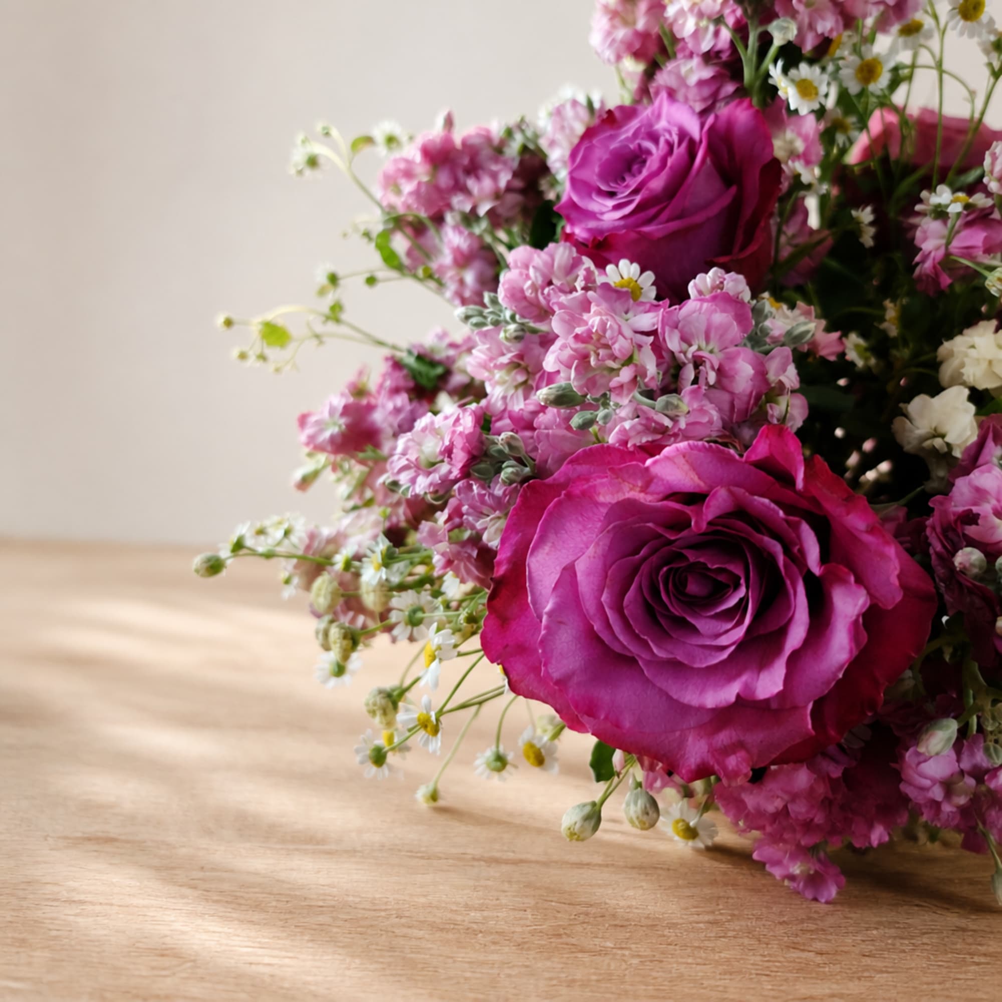 Pink and magenta rose bouquet with small white filler flowers
