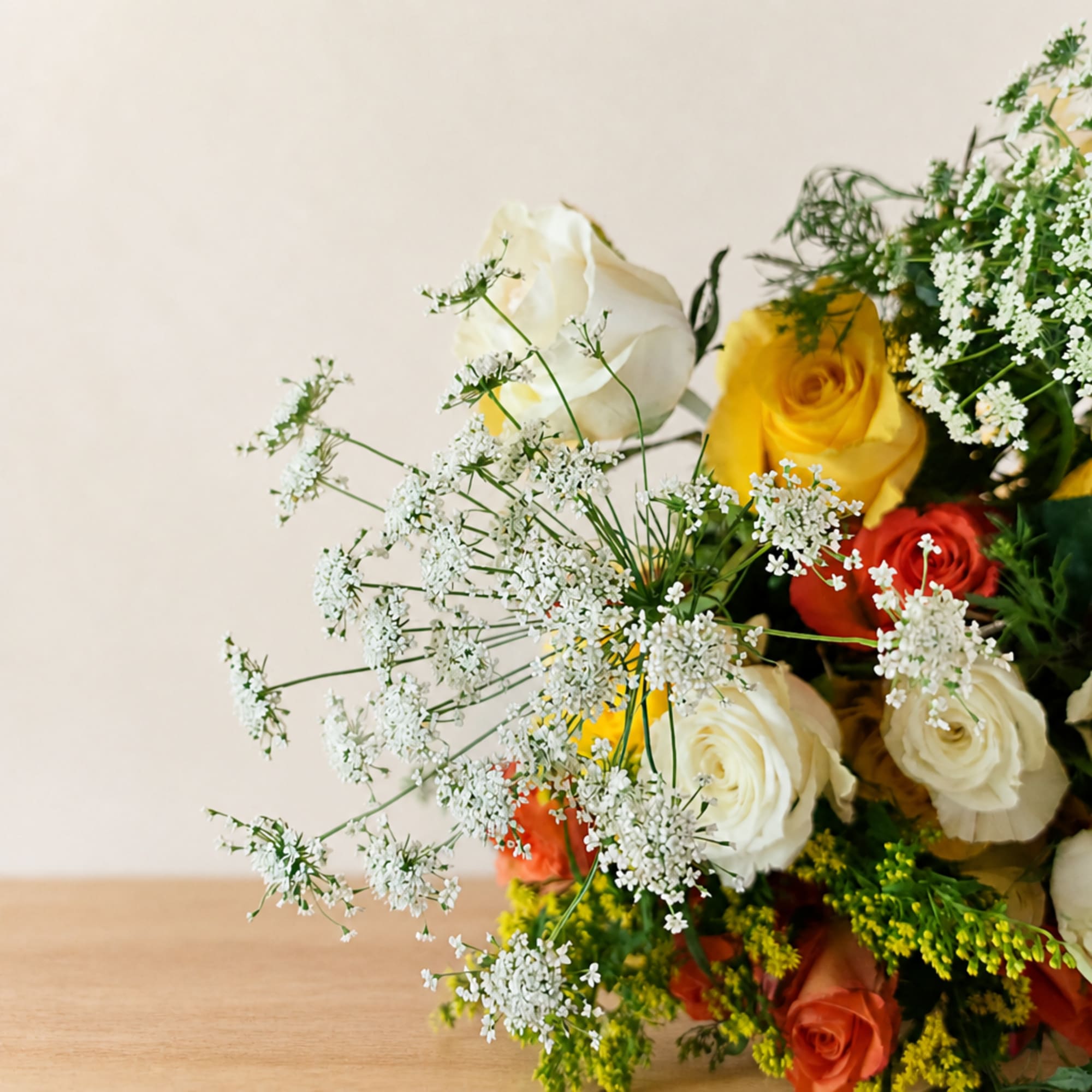 Bouquet of roses and white filler flowers on a table