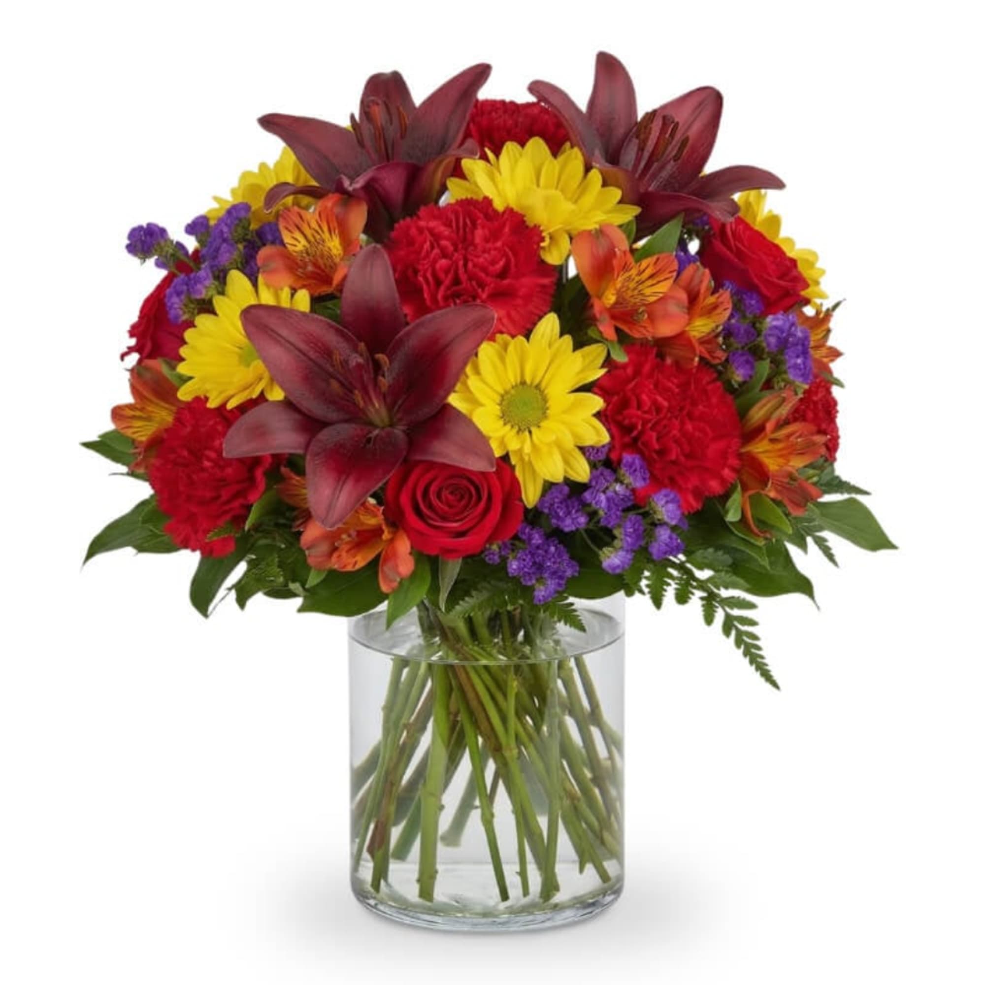 Mixed bouquet of red, yellow, and purple flowers in a clear glass vase