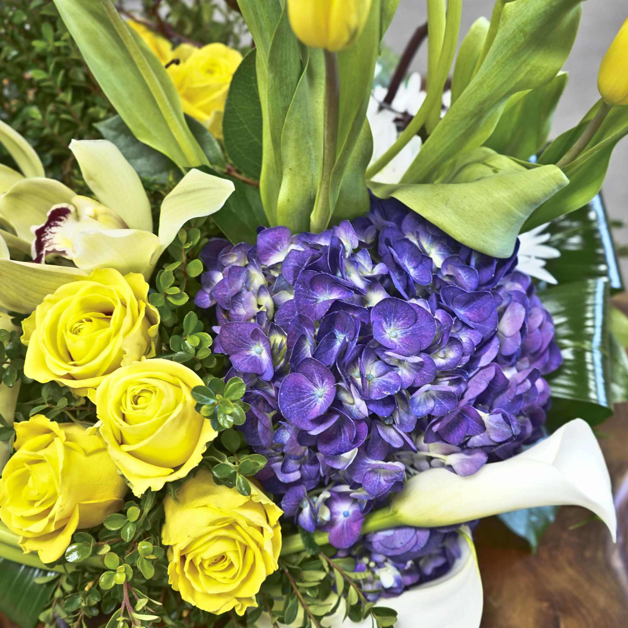 Bouquet of yellow roses, purple hydrangea, and white calla lilies
