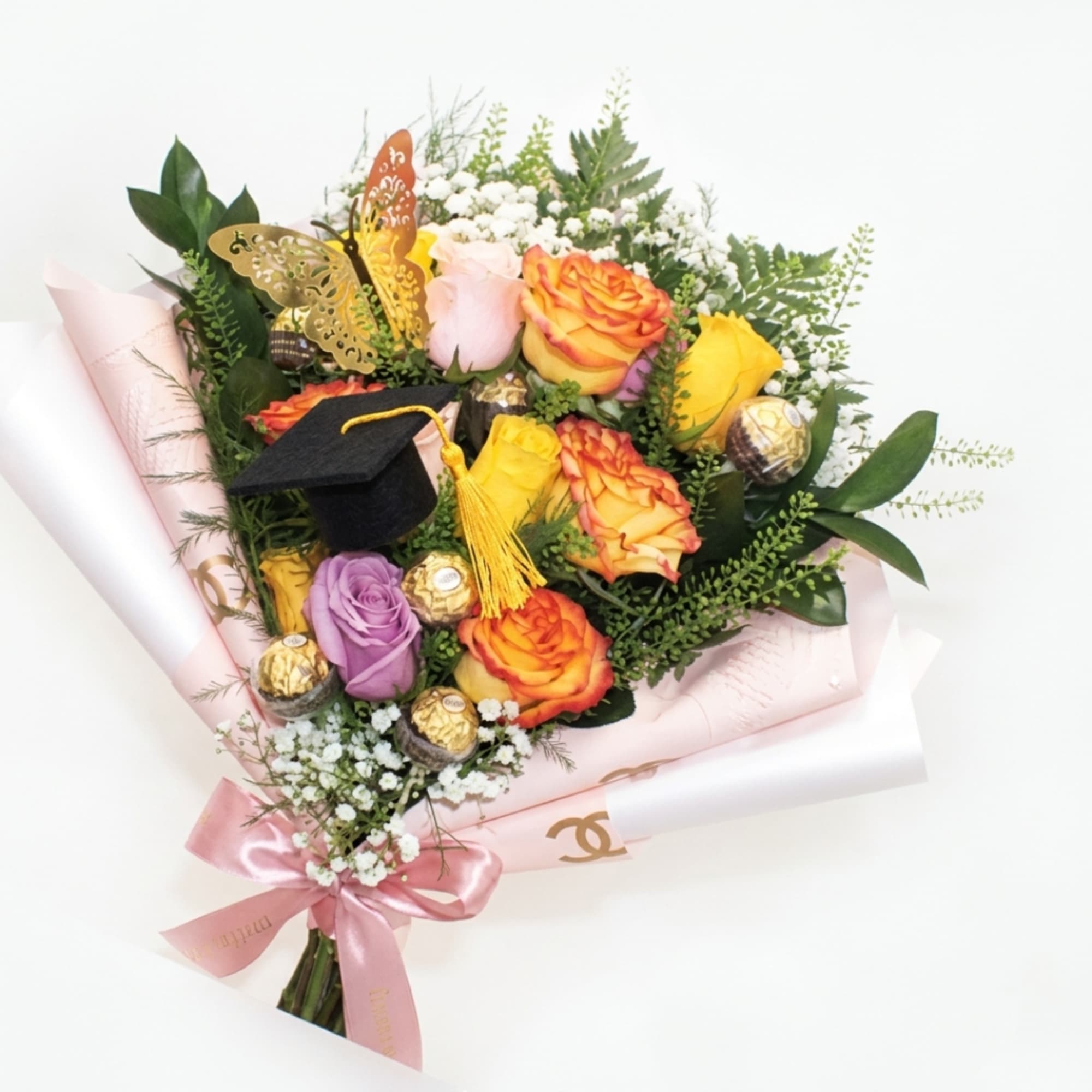 Bouquet of multicolored roses with a graduation cap and chocolates