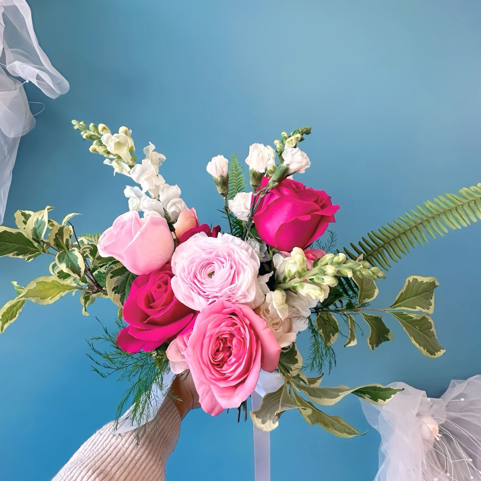 Pink and white rose bouquet with snapdragons and greenery