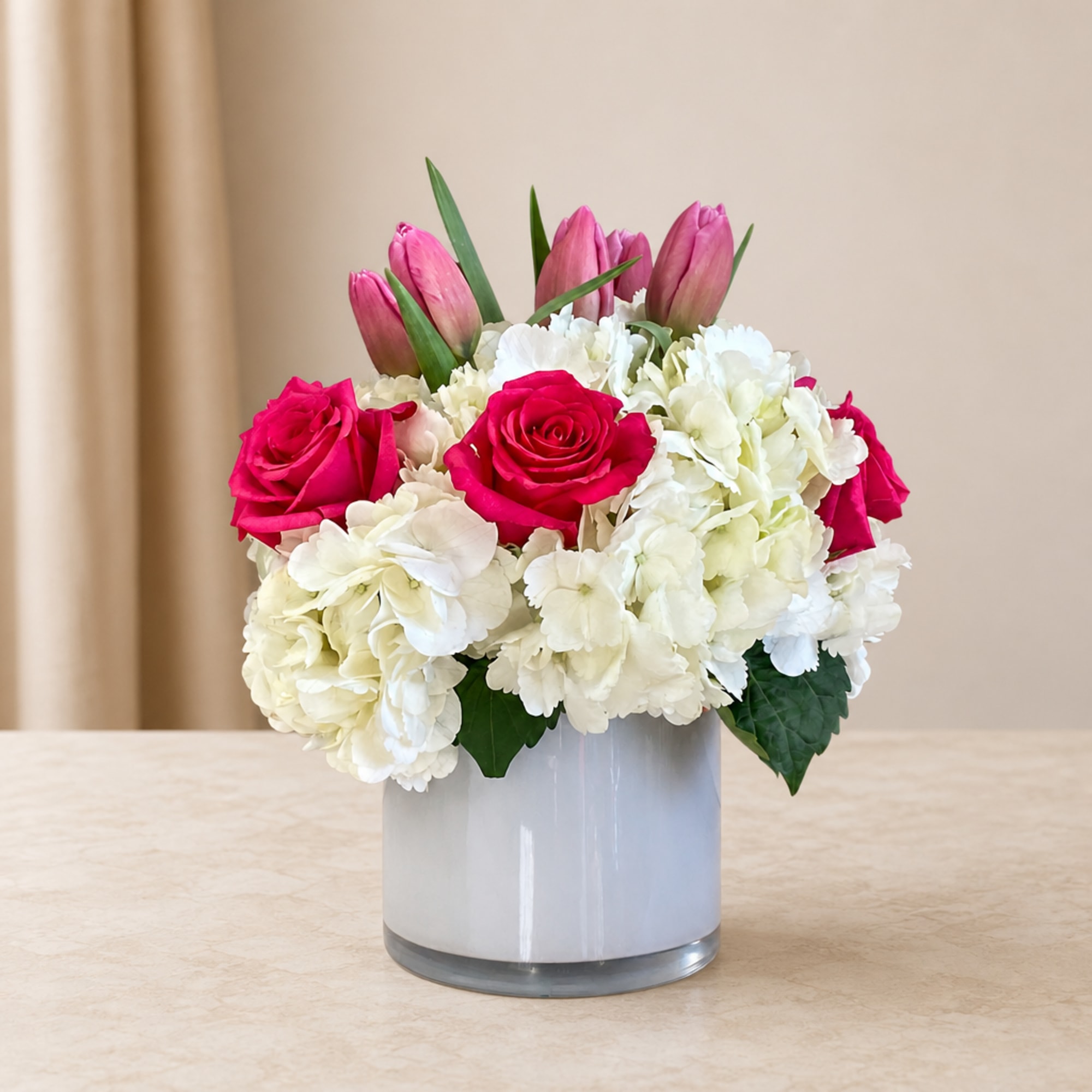 Pink roses and white hydrangeas in a white vase