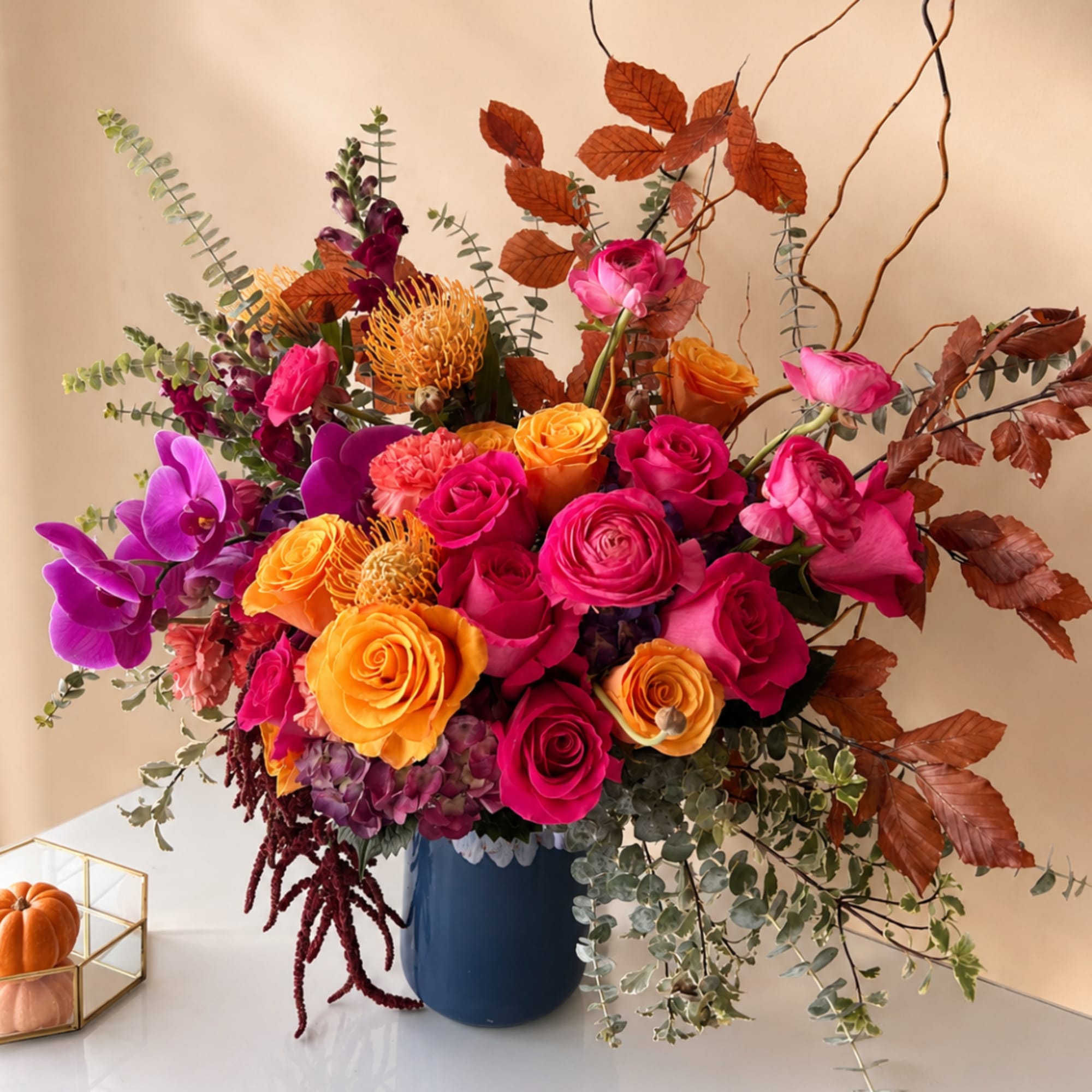 Bright mixed bouquet in a blue vase with pink and orange blooms