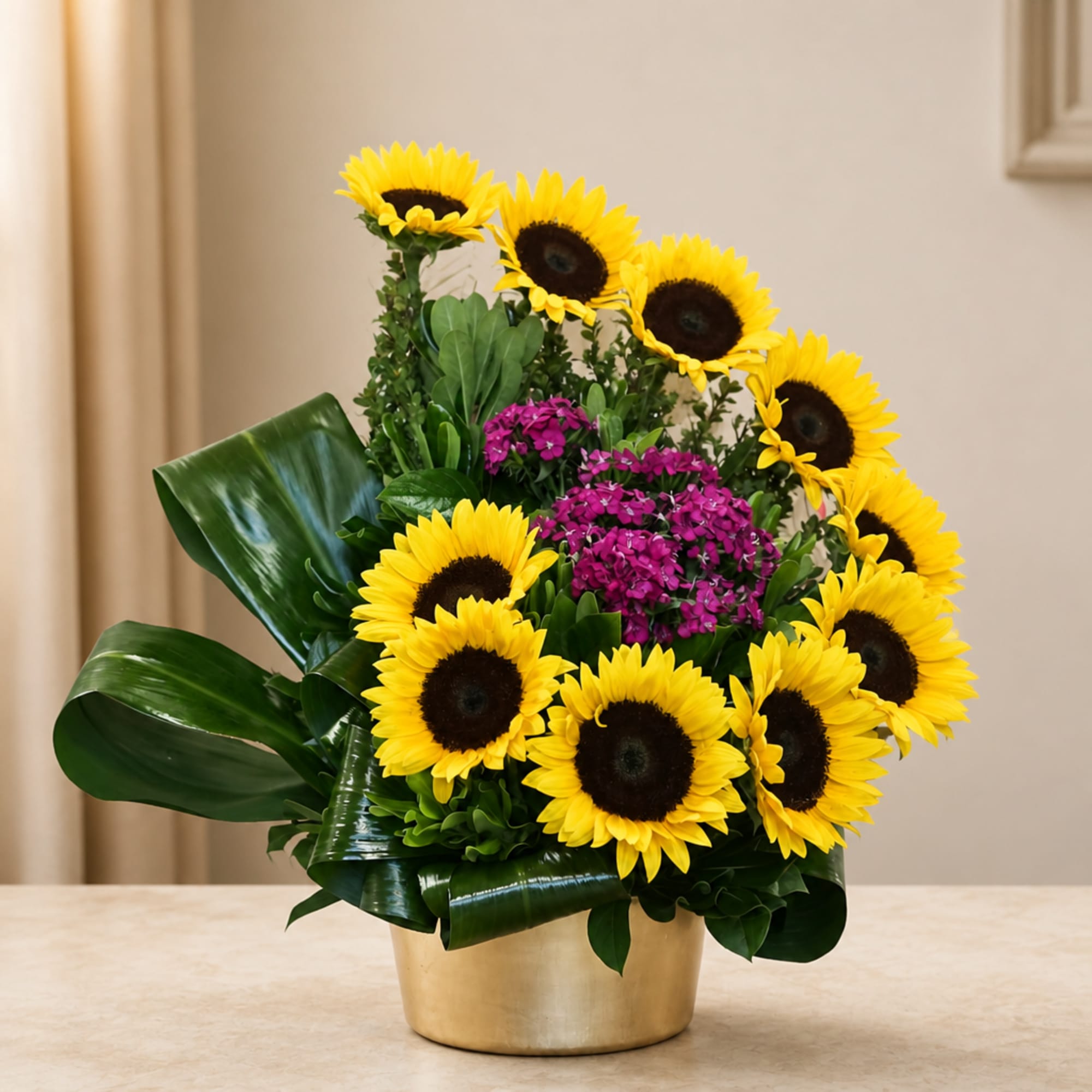 Sunflower arrangement with purple flowers in a gold container