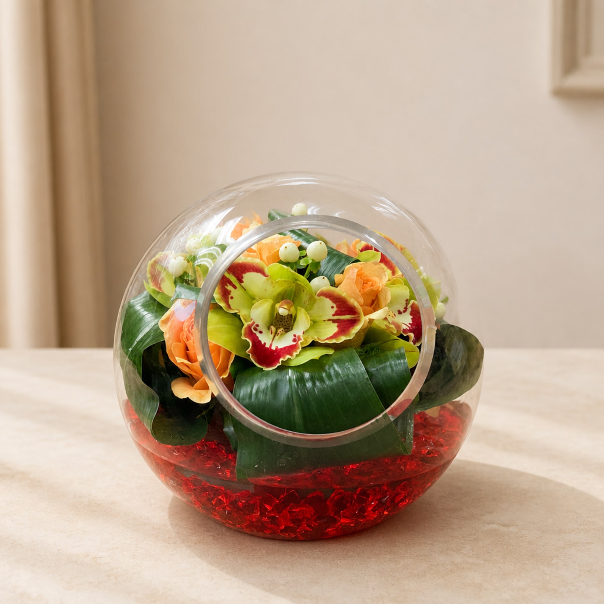 Round glass vase with orange and green flowers and red filler