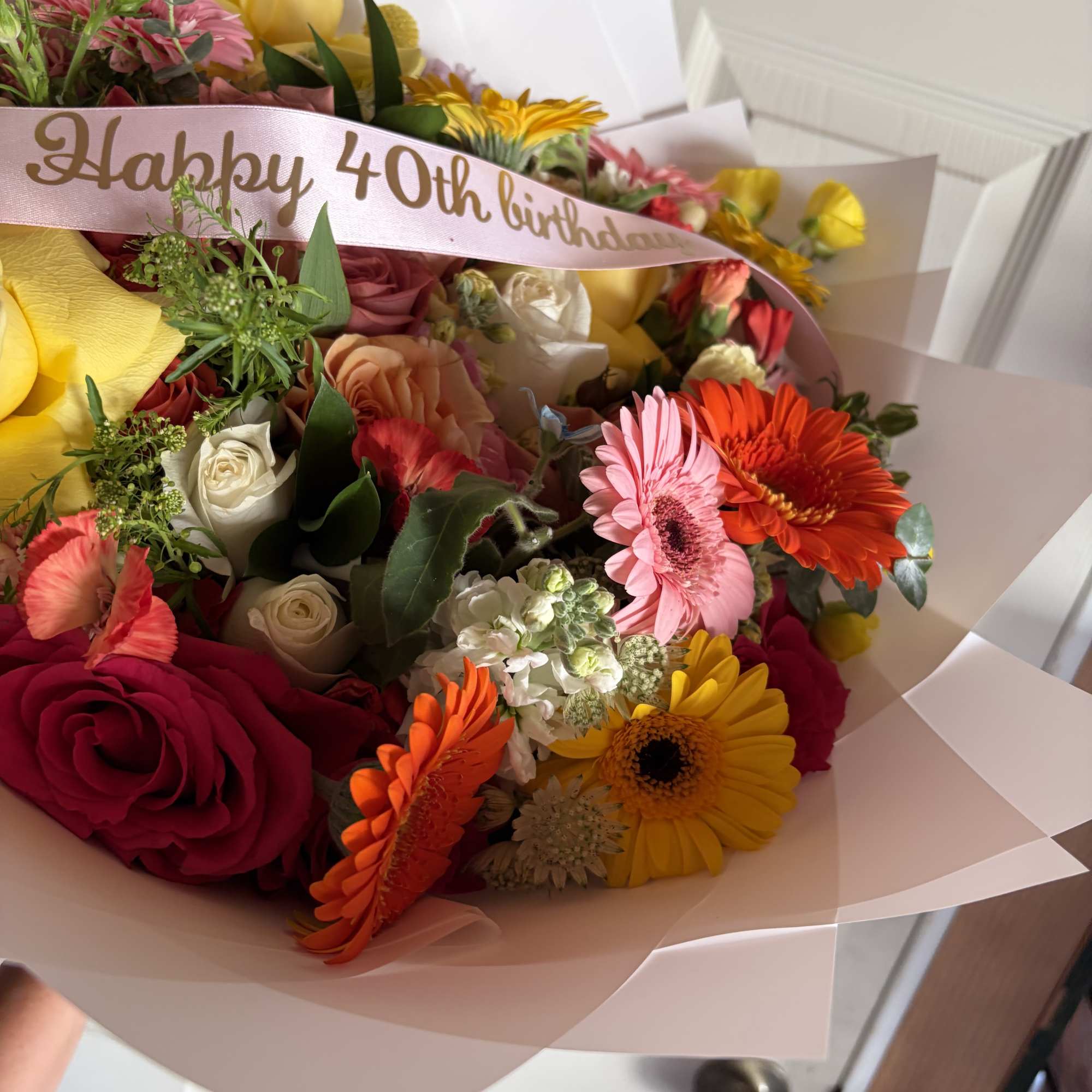 Mixed bouquet with roses, gerbera daisies, and a "Happy 40th birthday" ribbon