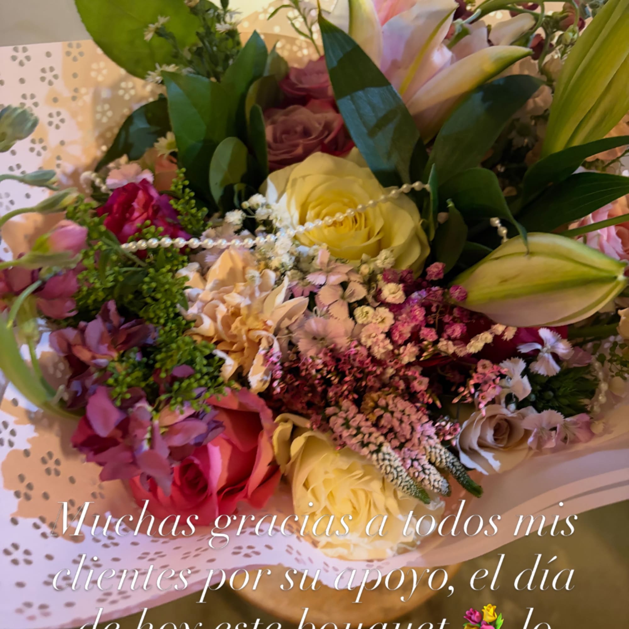 Mixed bouquet of roses, lilies, and small filler flowers in pastel tones