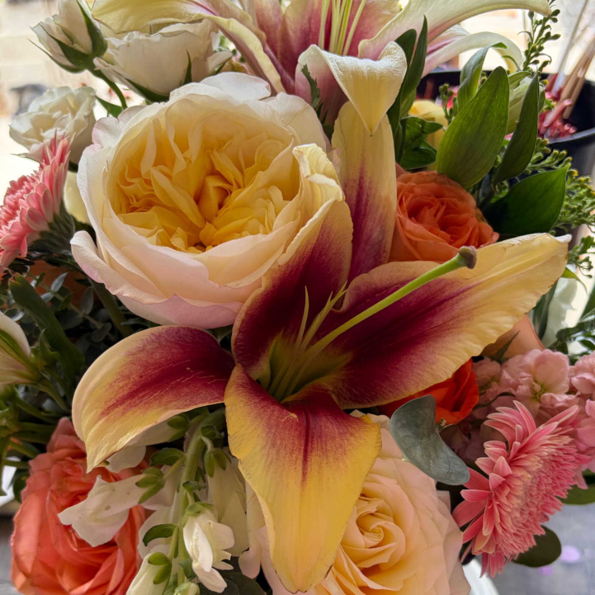 Mixed bouquet with cream roses and large pink-and-yellow lilies