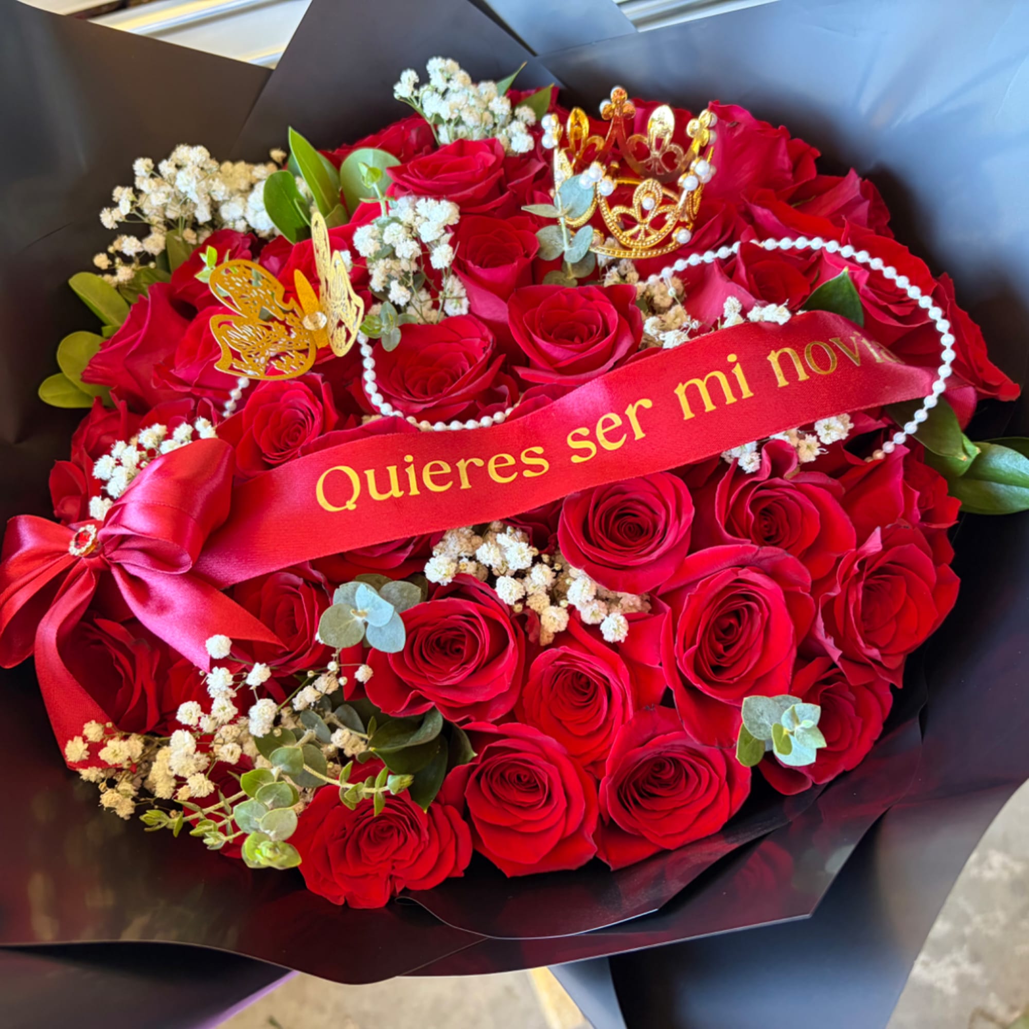 Bouquet of red roses with a ribbon and decorative crowns