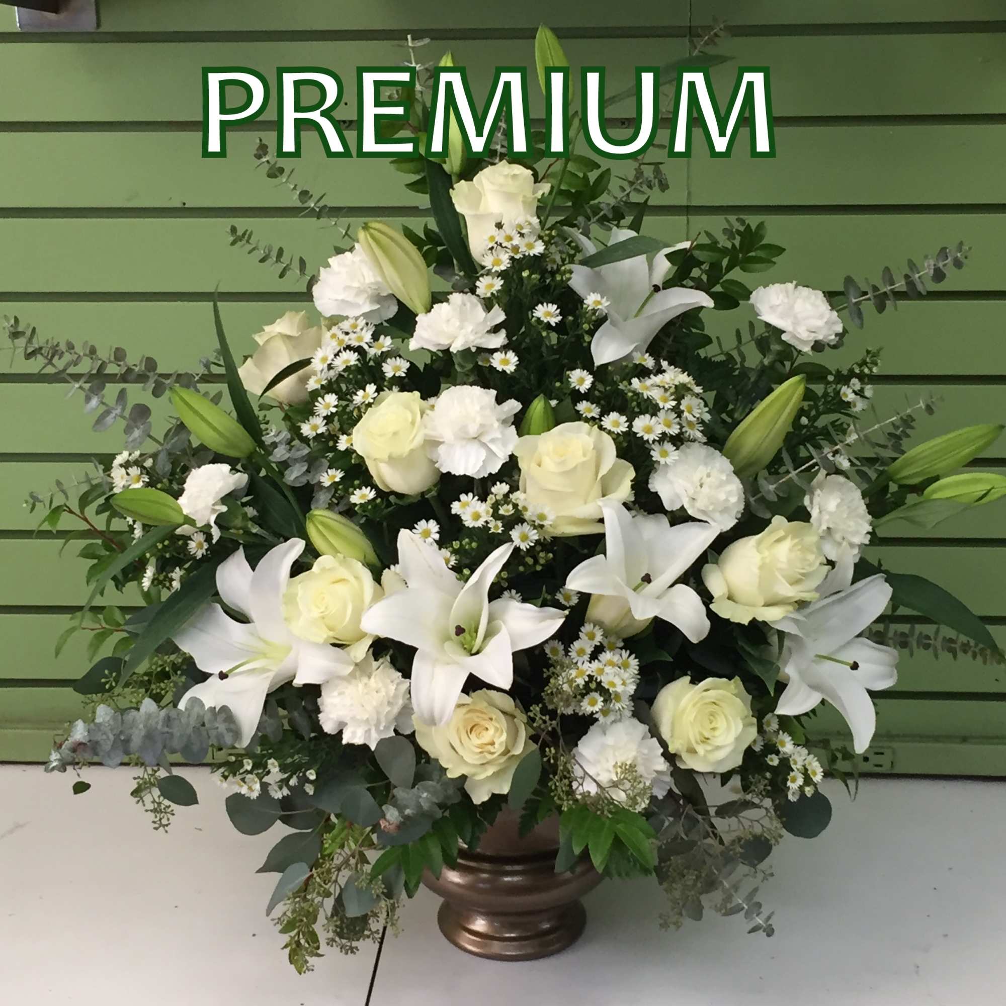 White lilies and roses arranged in a bronze vase