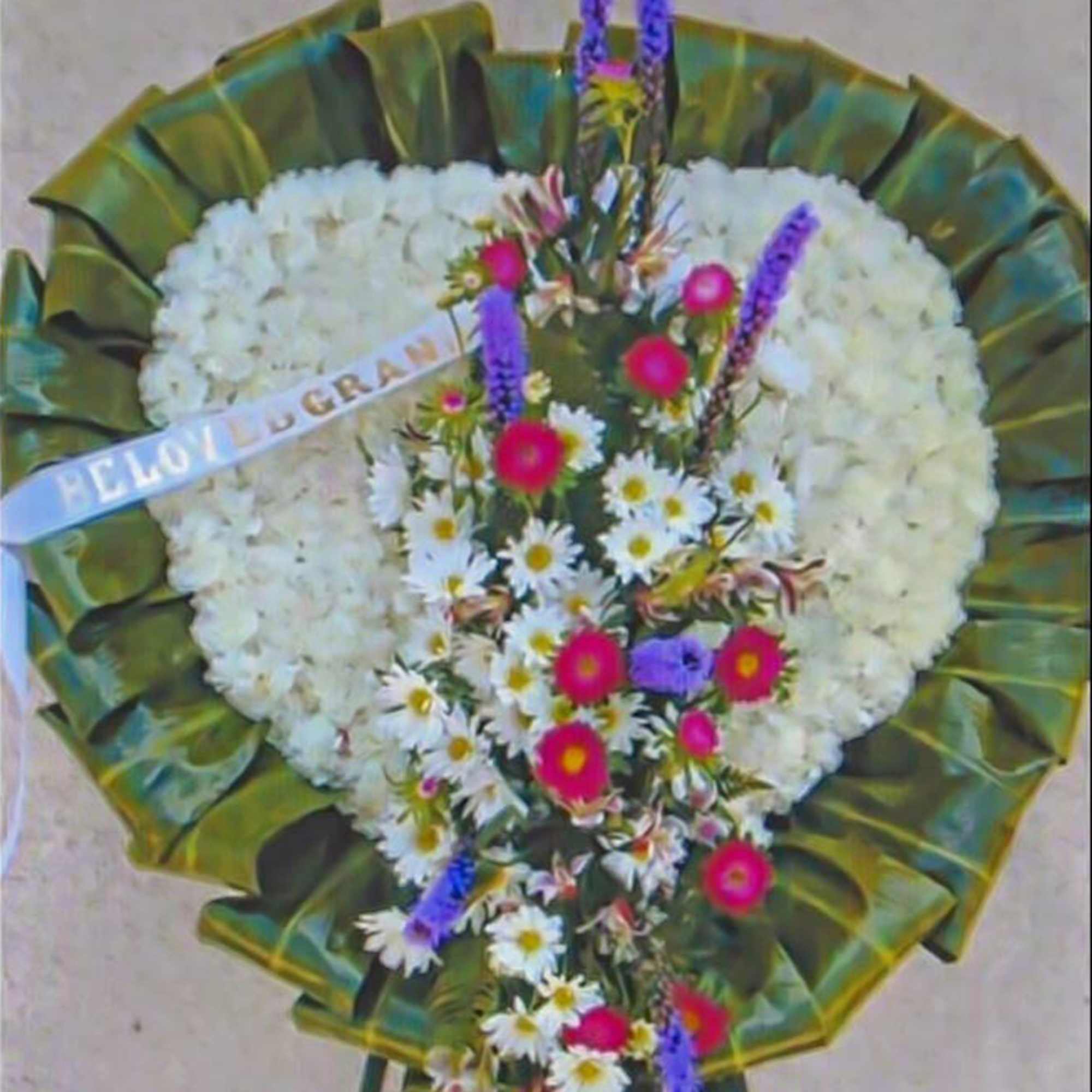 Heart-shaped white funeral wreath with daisy spray and memorial ribbon