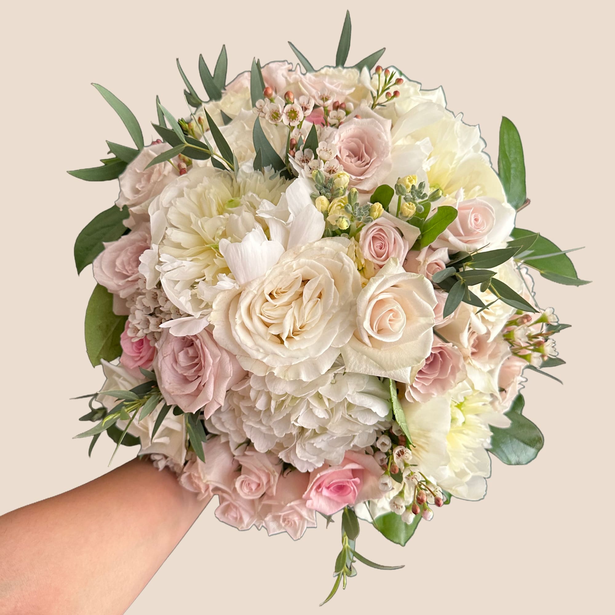 Handheld bouquet of blush and white roses with mixed blooms