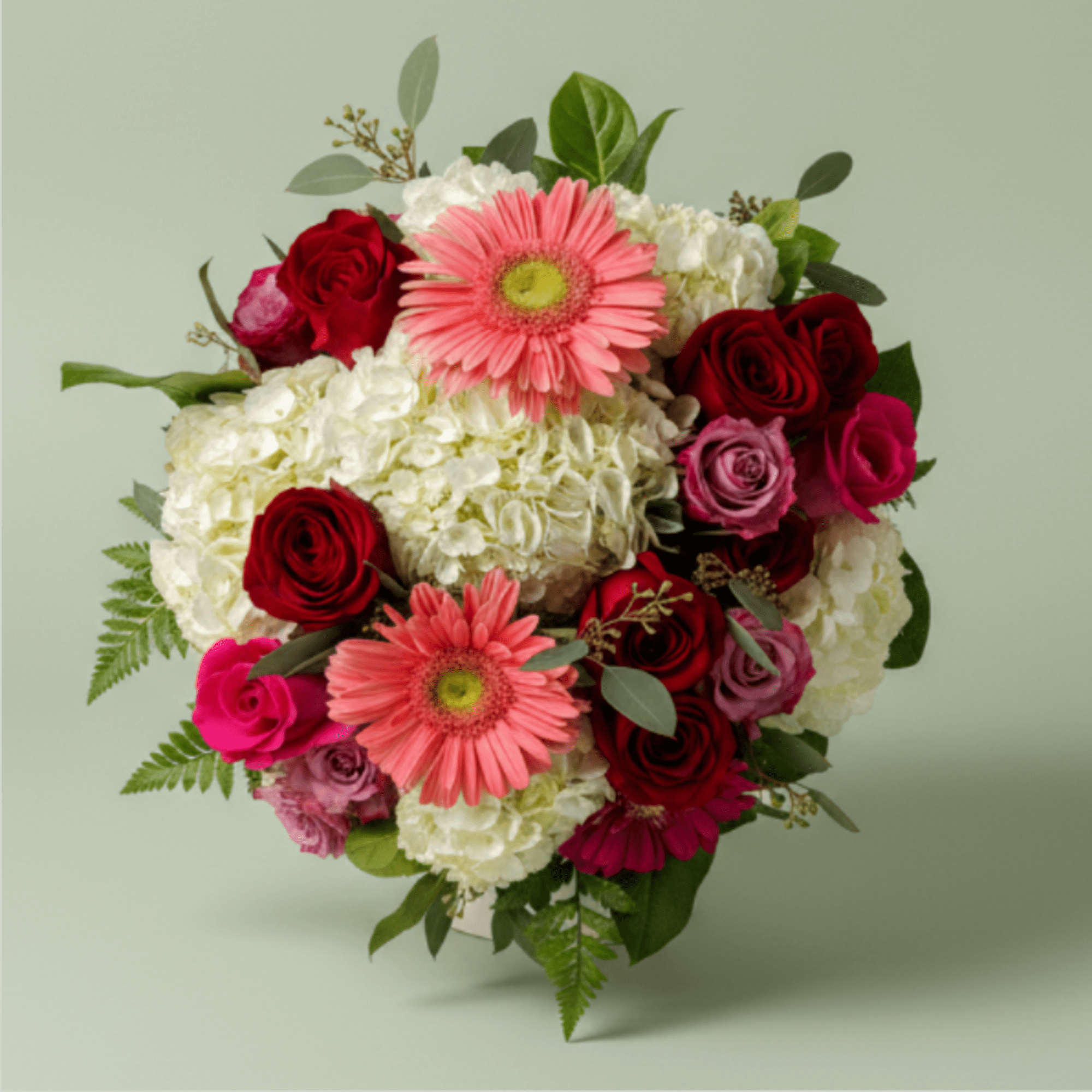 Bouquet of pink gerbera daisies, red roses, and white hydrangeas
