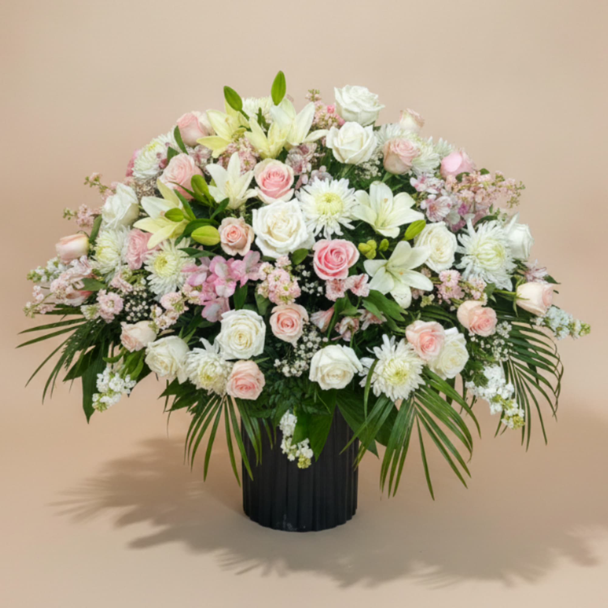 A softly layered casket spray in white, blush pink and pale green, photo 3 of 3