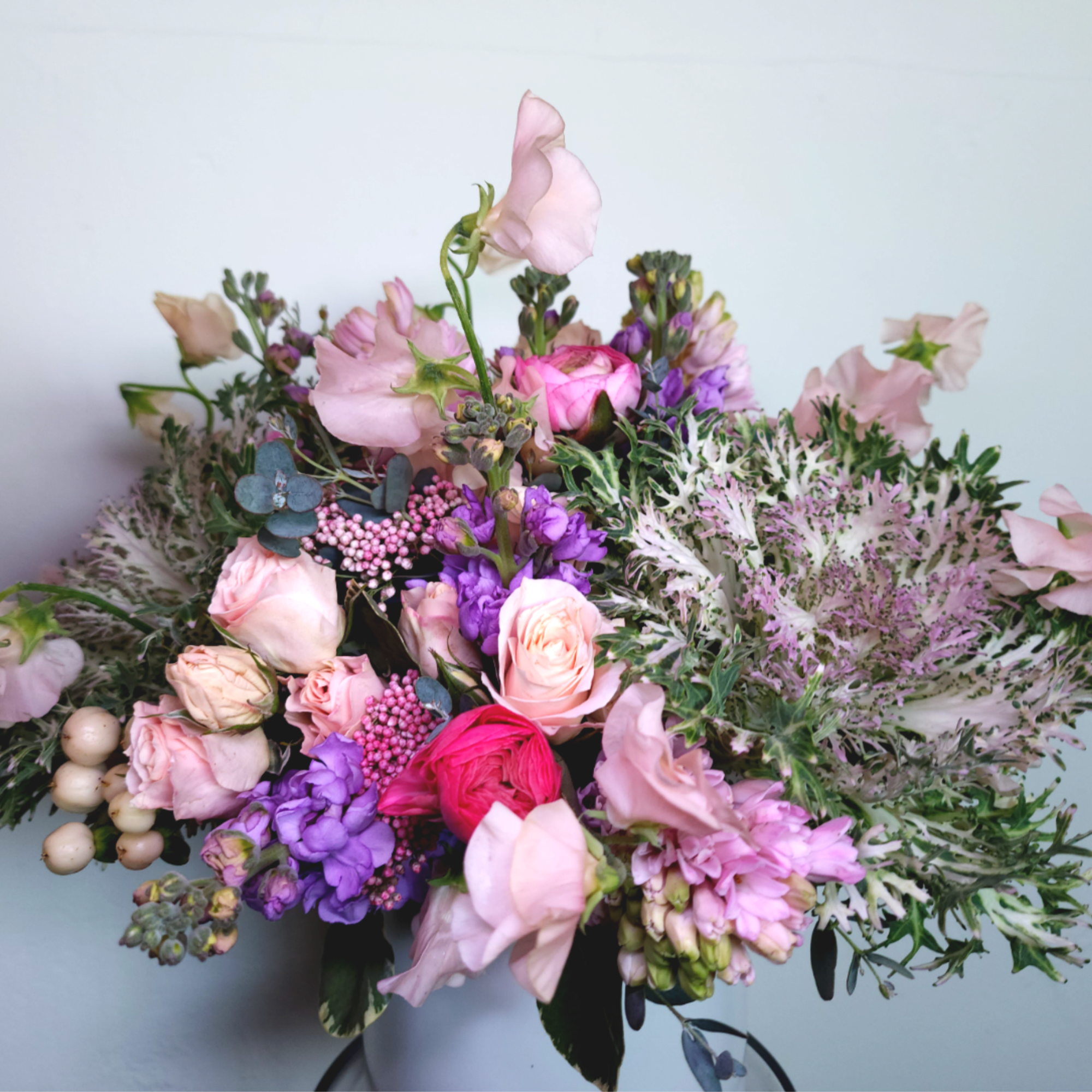 Bouquet of pink and purple flowers with pale greenery