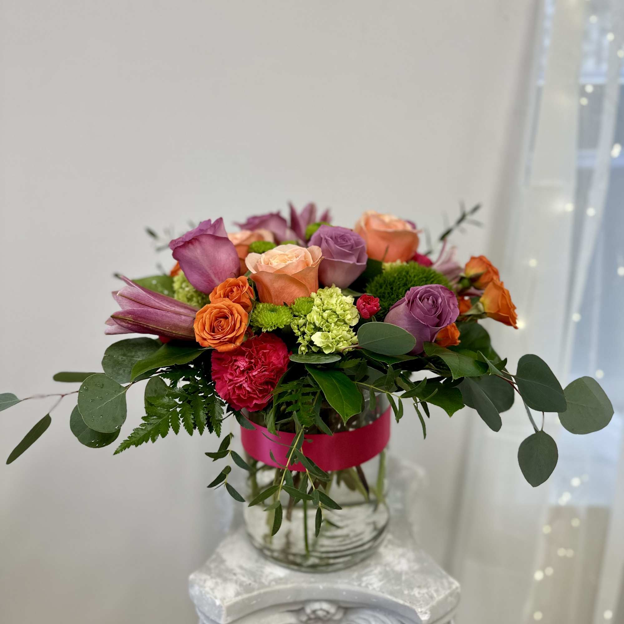 Mixed bouquet of roses and lilies in a glass vase