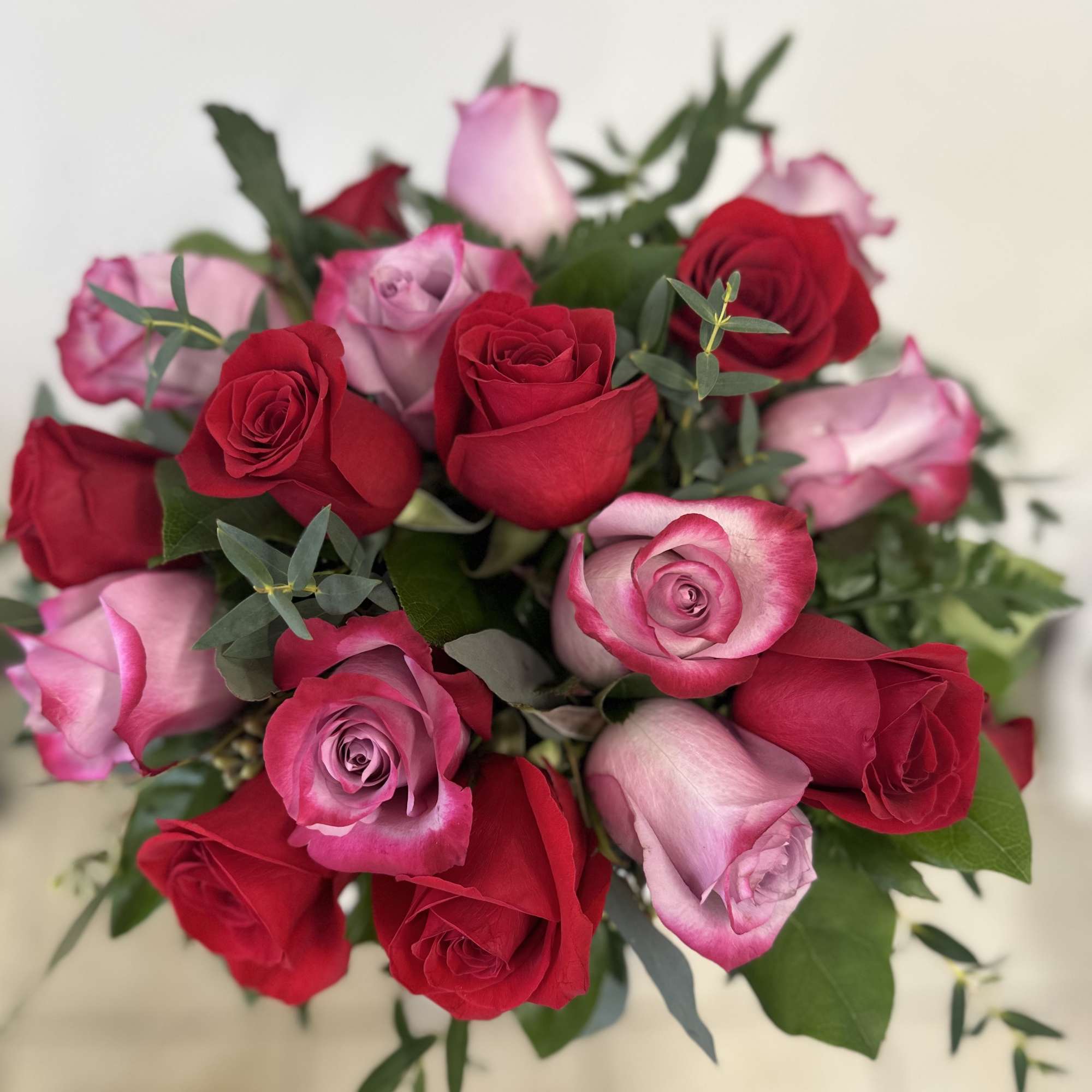 Bouquet of red and pink roses with greenery