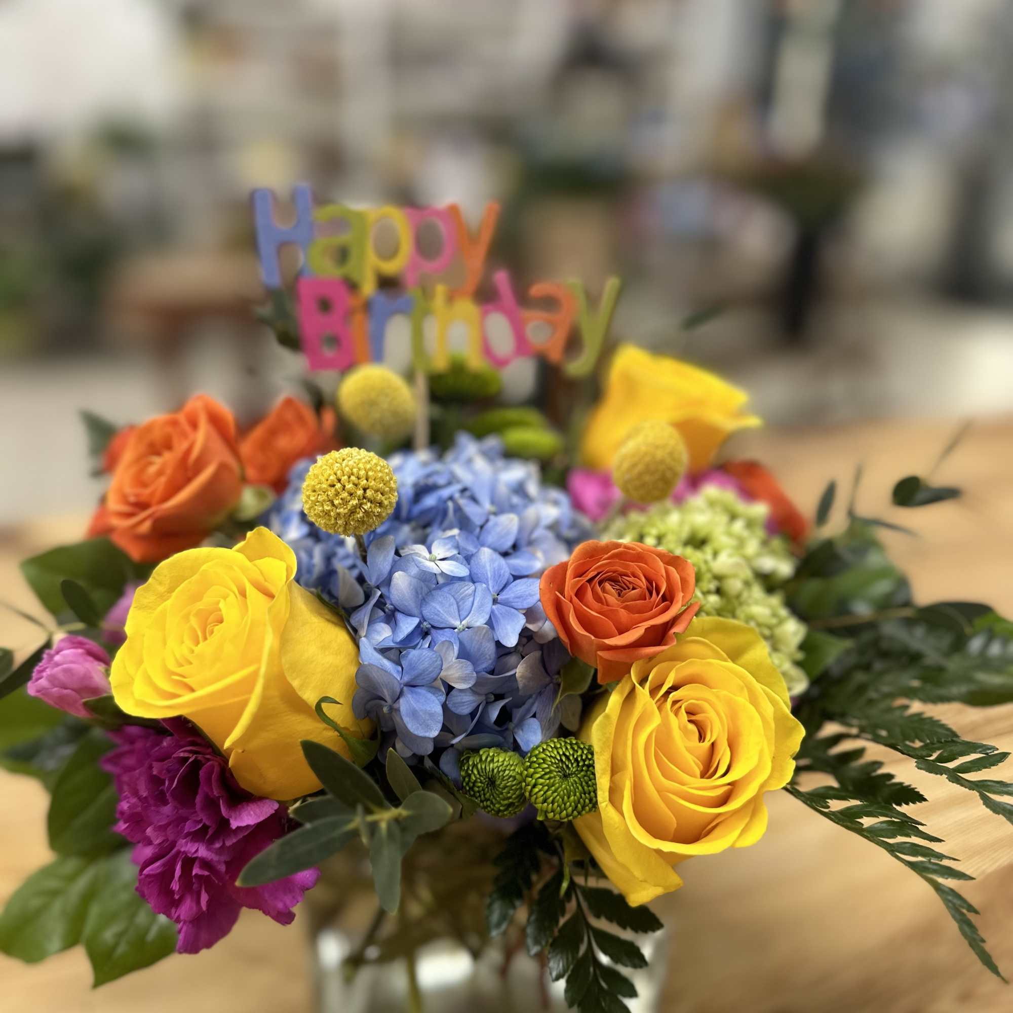 Colorful birthday flower arrangement in a glass vase