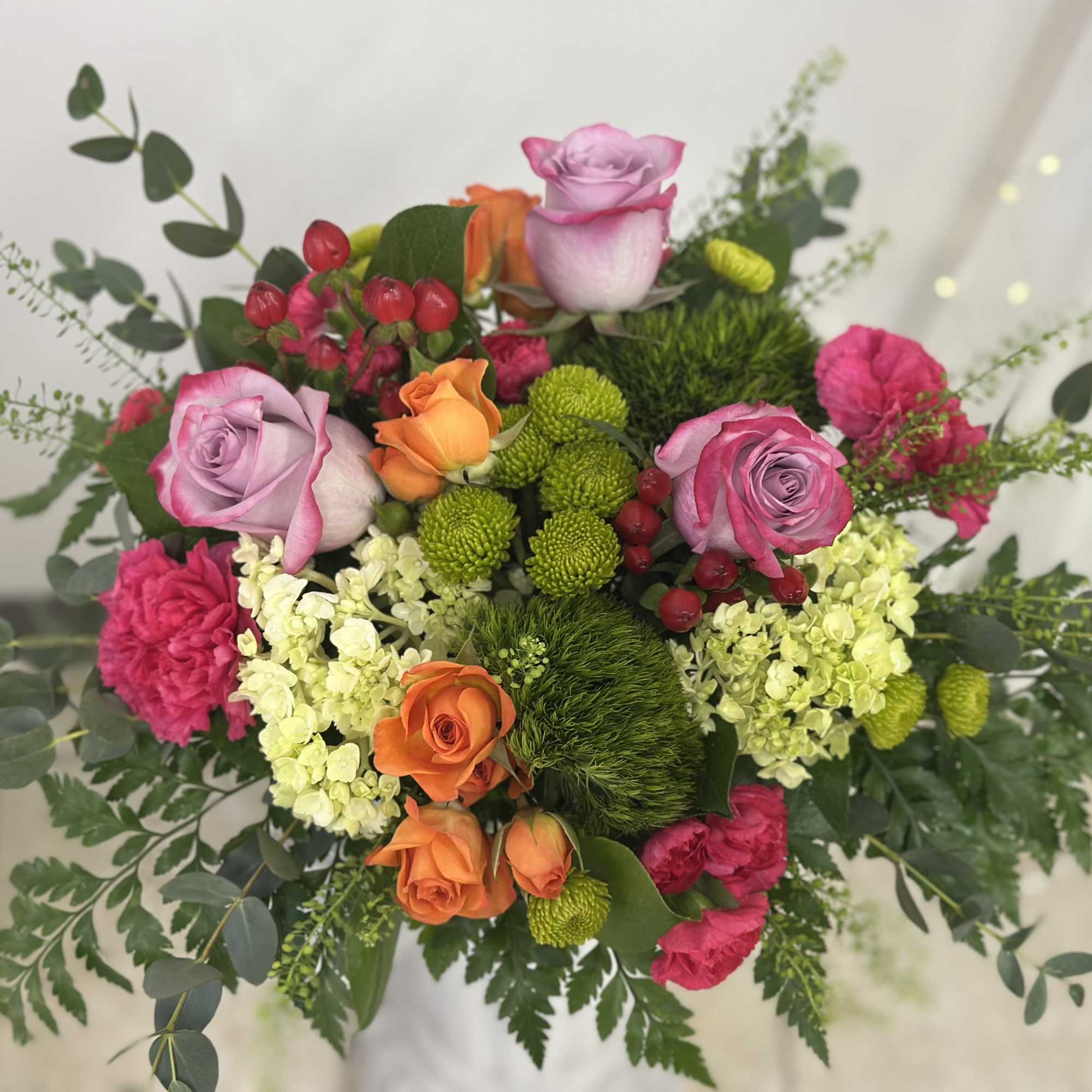 Bouquet of pink and orange roses with green pompons and white blooms