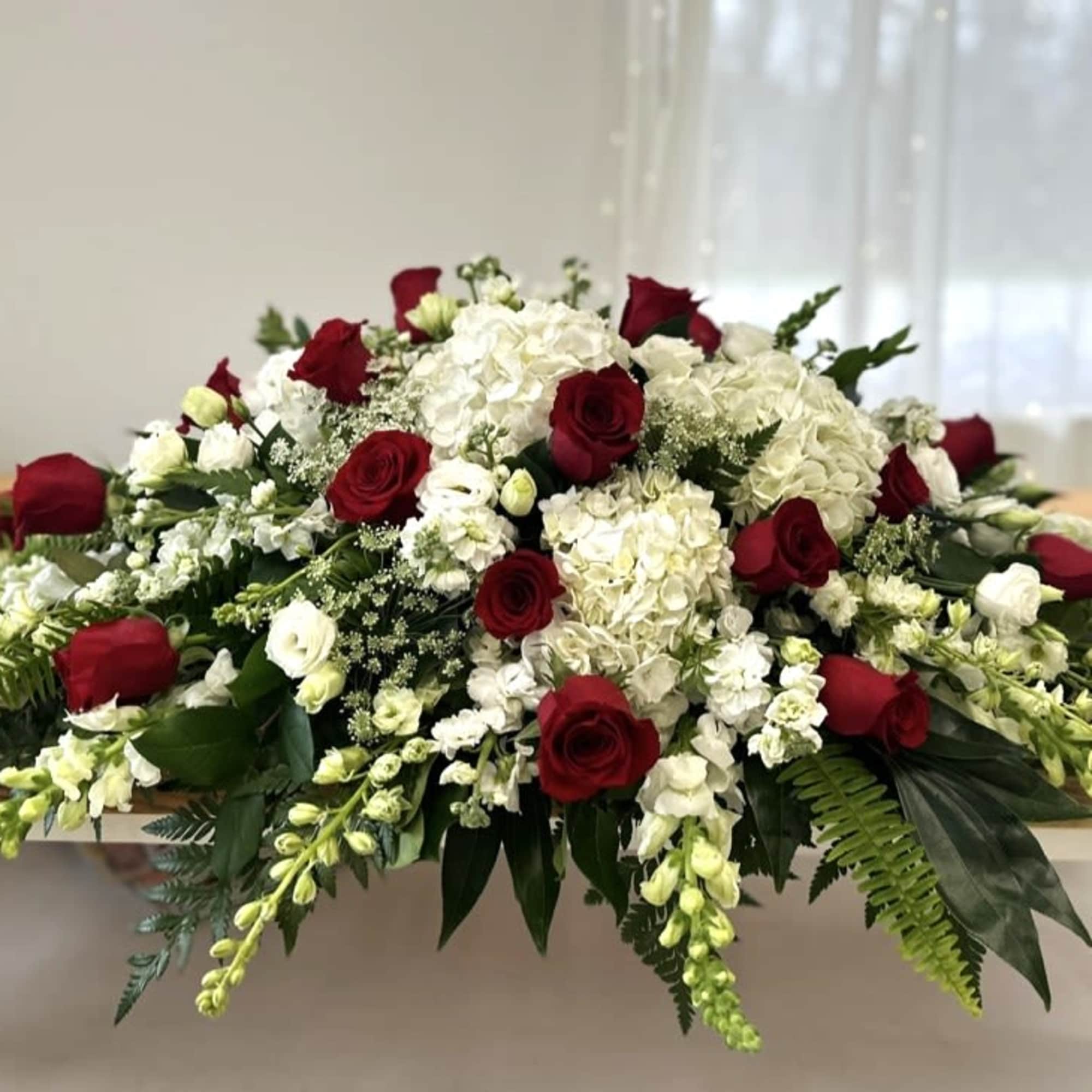 Low floral centerpiece with red roses and white hydrangeas