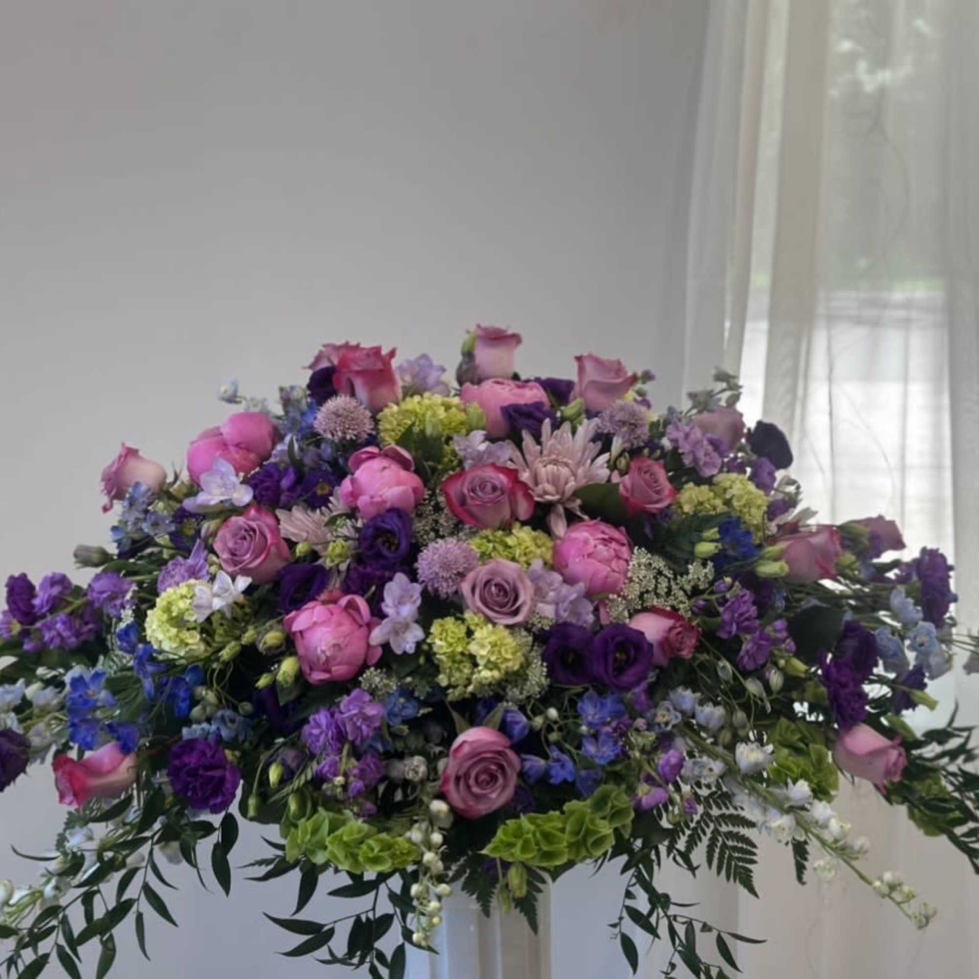 Large purple and pink floral arrangement with roses and mixed blooms