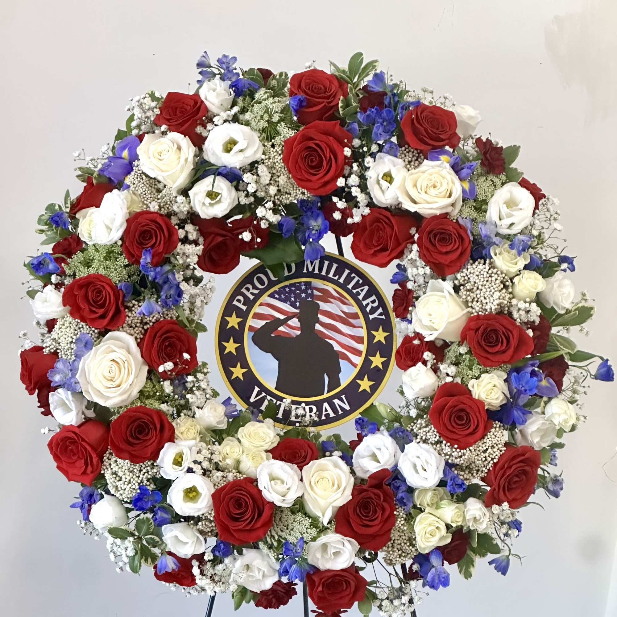 Circular wreath of red, white, and blue flowers on an easel
