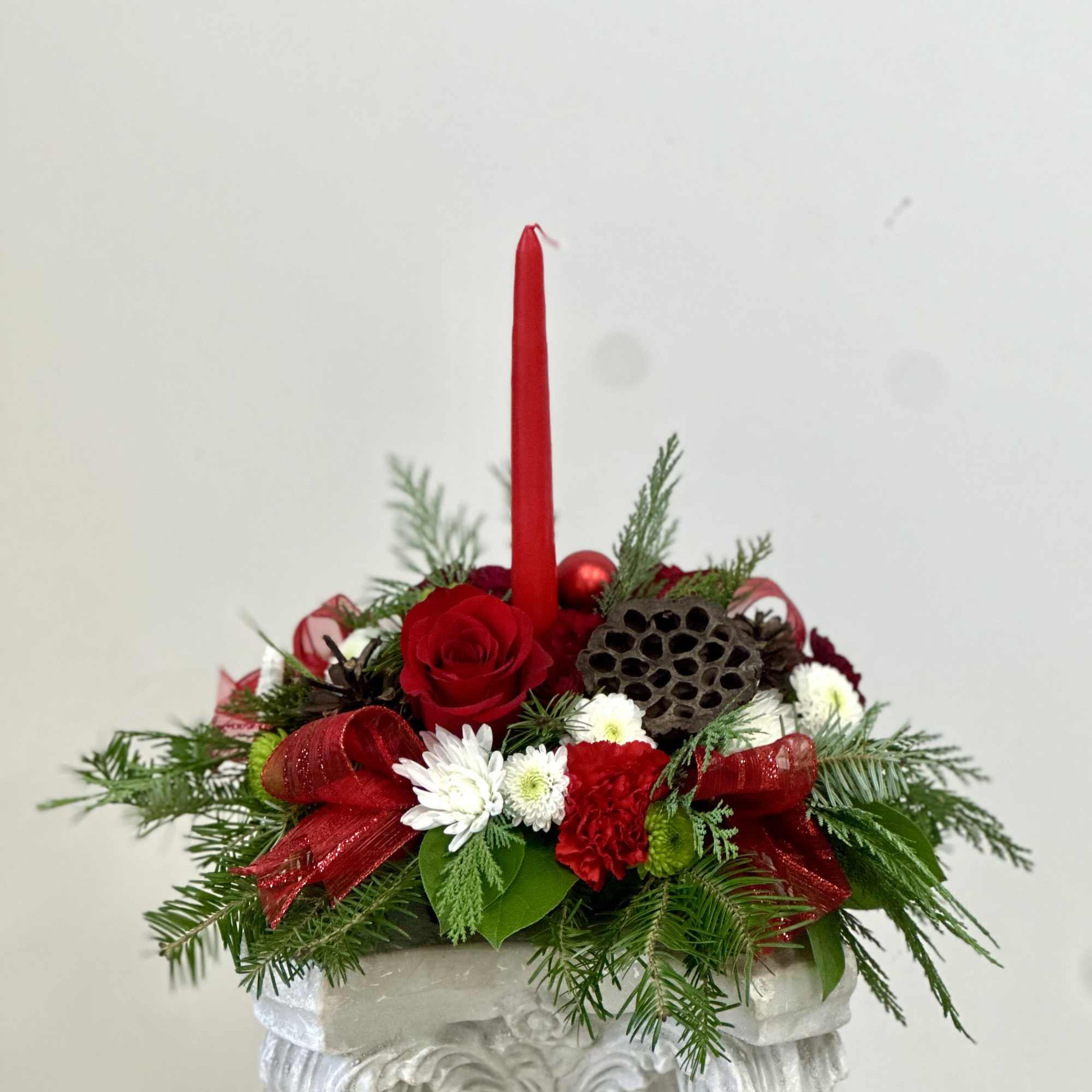 Elevate your holiday celebrations with the Evergreen Candlelight Centerpiece by Westford Florist