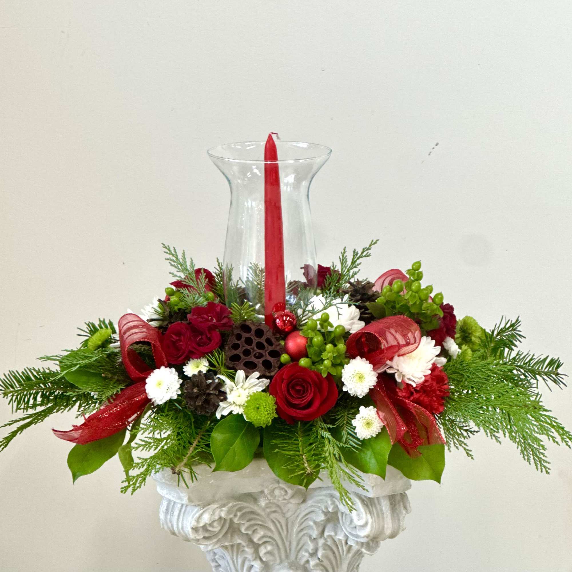 Elevate your holiday celebrations with the Evergreen Candlelight Centerpiece by Westford Florist
