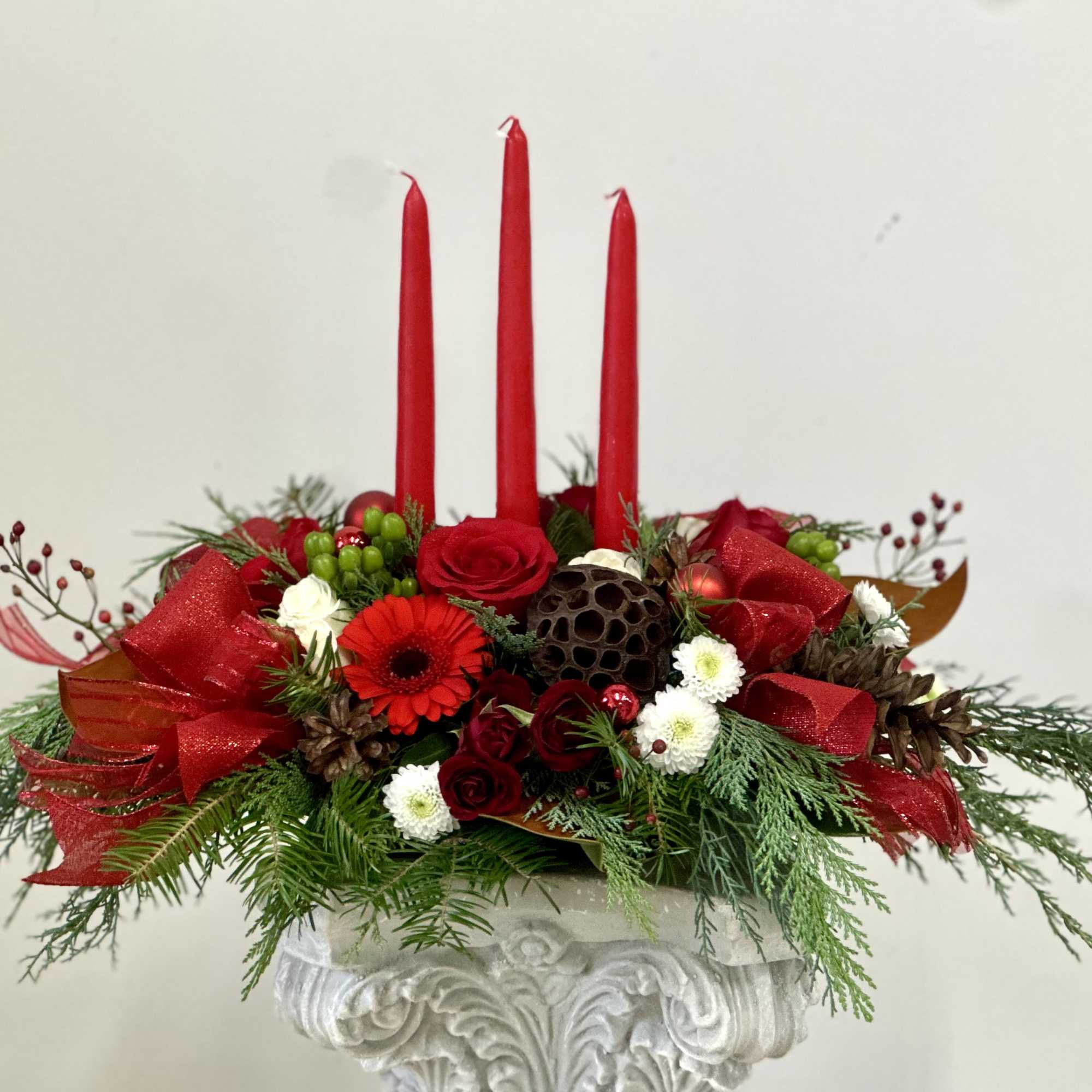 Elevate your holiday celebrations with the Evergreen Candlelight Centerpiece by Westford Florist