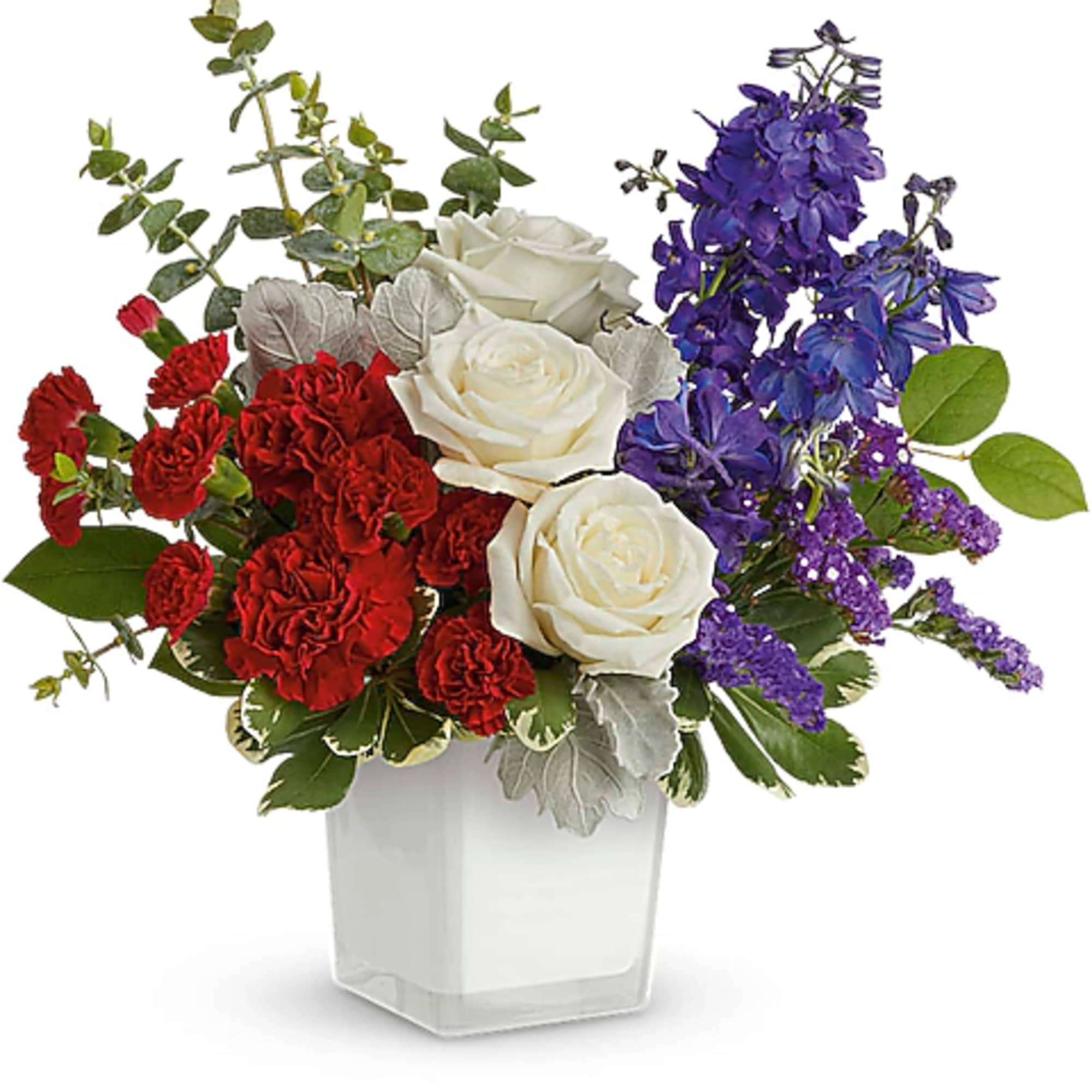 Red and white roses with purple flowers in a clear square vase