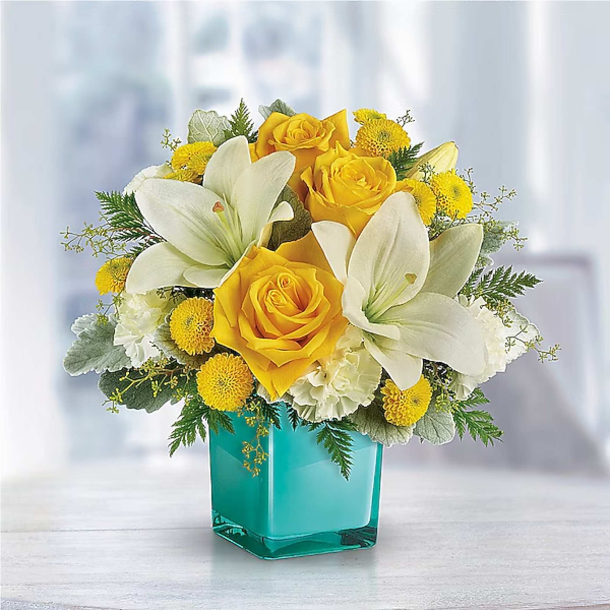 Yellow roses and white lilies in a turquoise vase