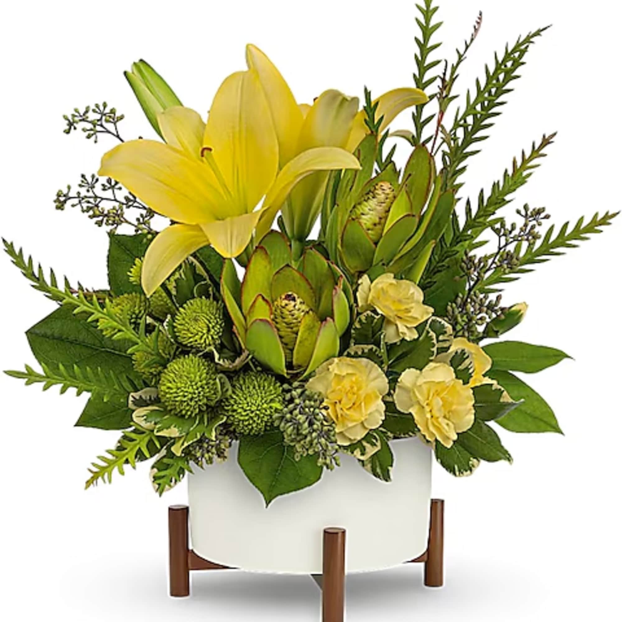 Yellow lilies and green protea in a white planter on a wooden stand