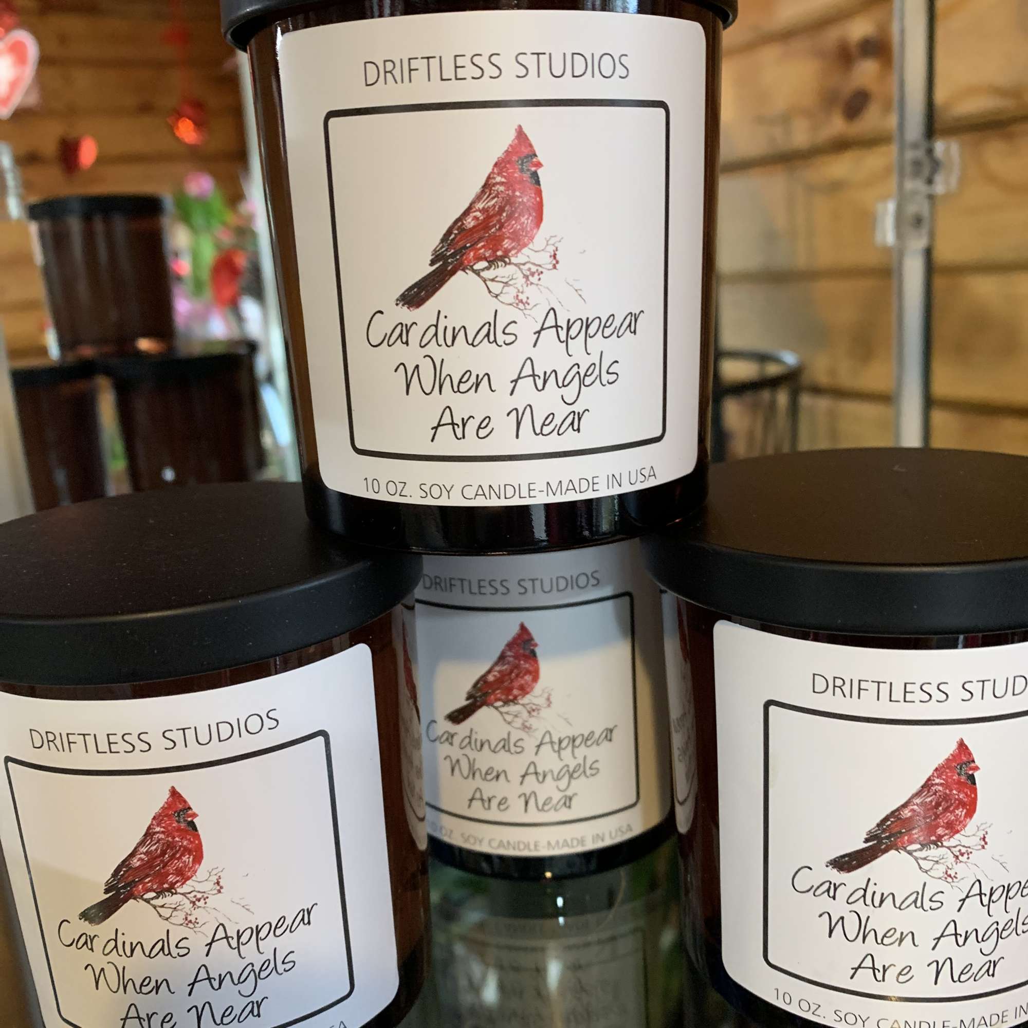 Three labeled soy candles with cardinal artwork stacked together