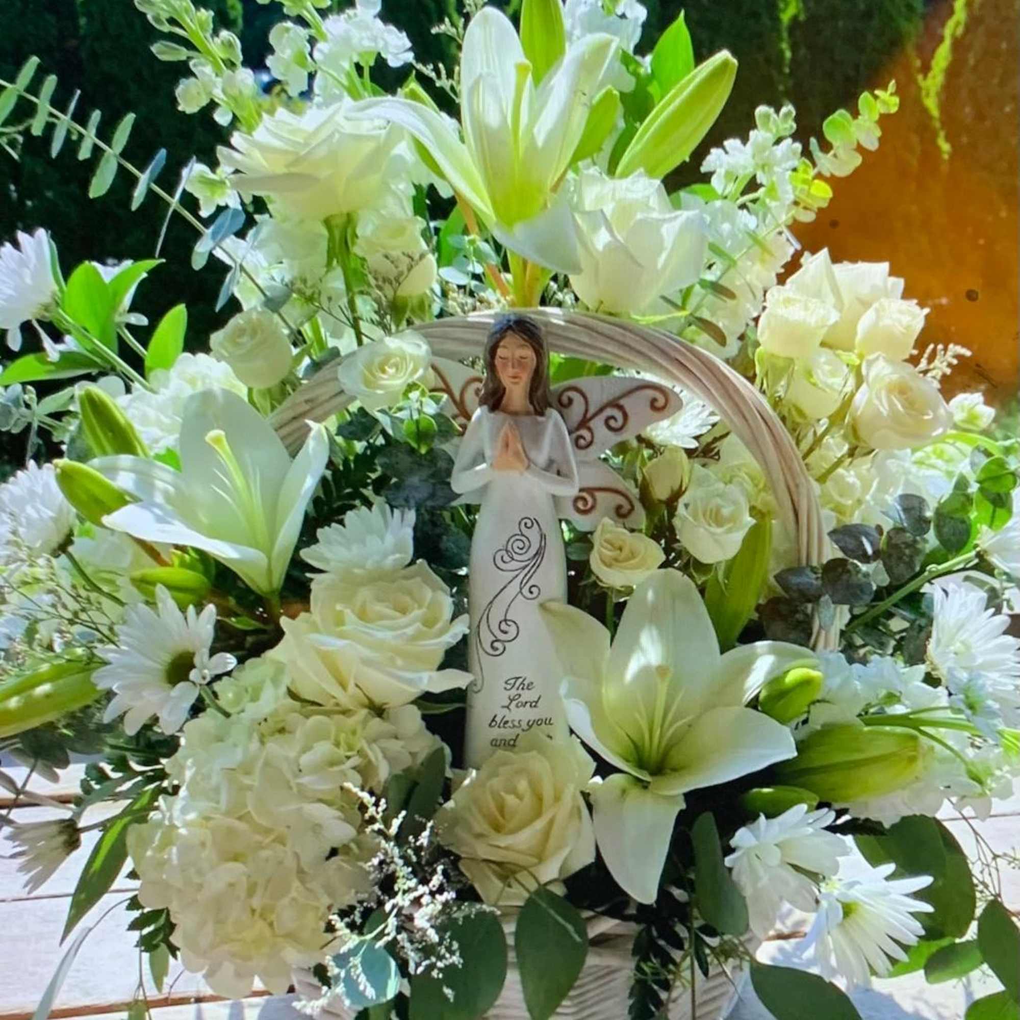 White floral basket with an angel figurine in the center