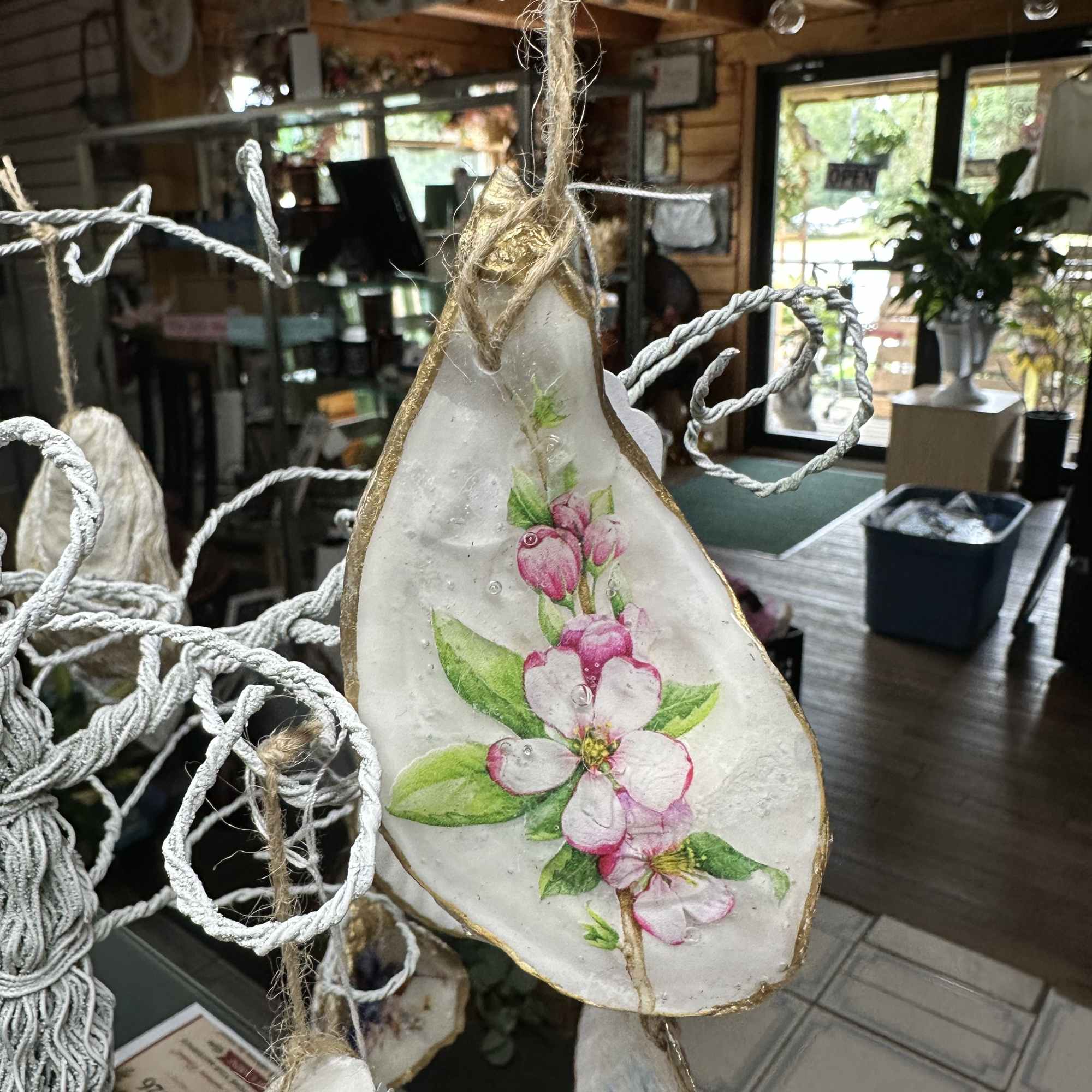 Hanging shell ornament painted with pink blossoms