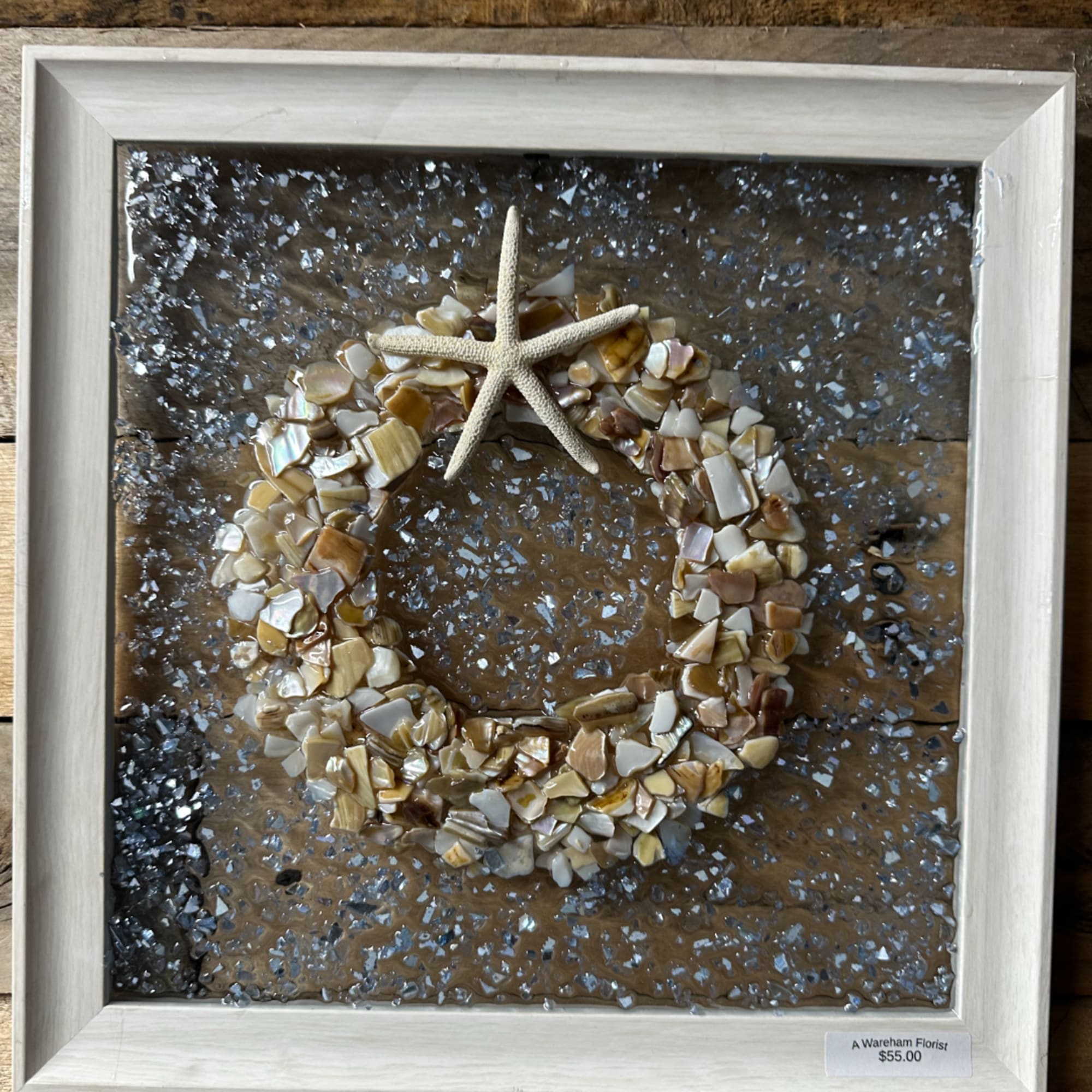 Framed seashell wreath with a starfish on a textured background