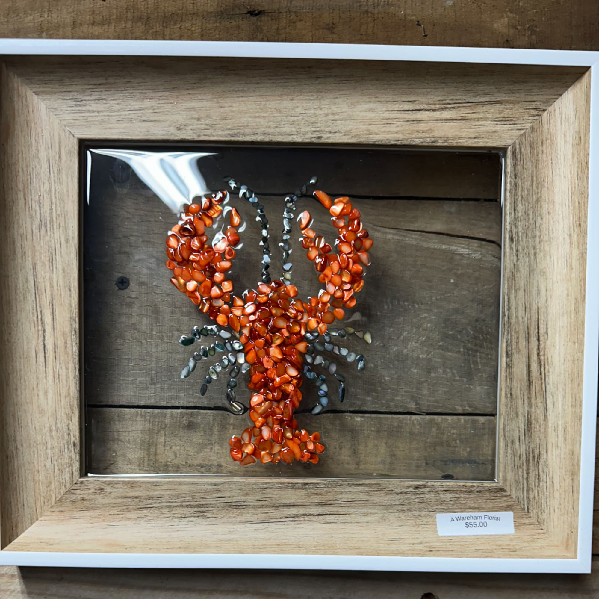 Framed crab artwork made from orange and gray stones
