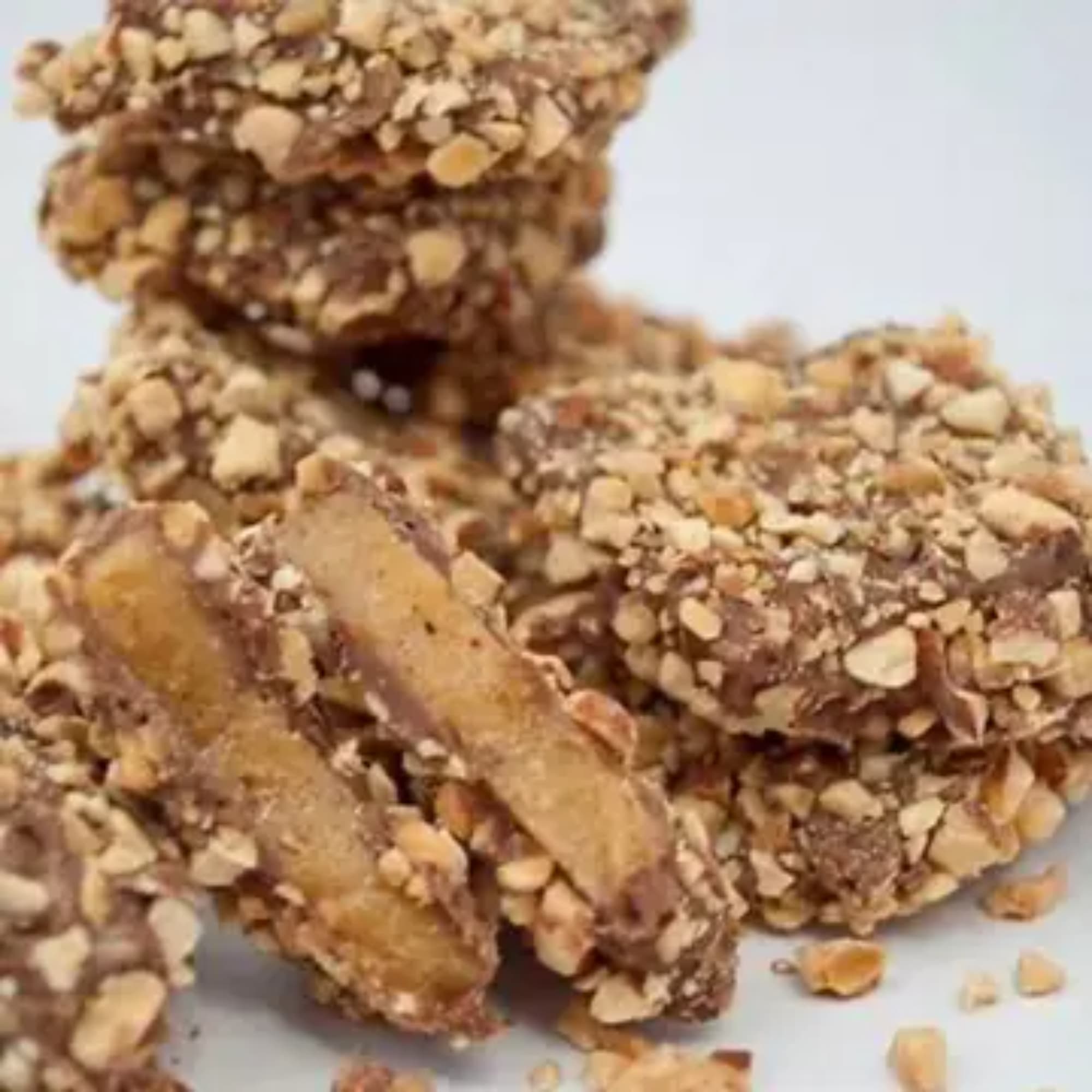 Stacked nut brittle candy pieces on a white surface