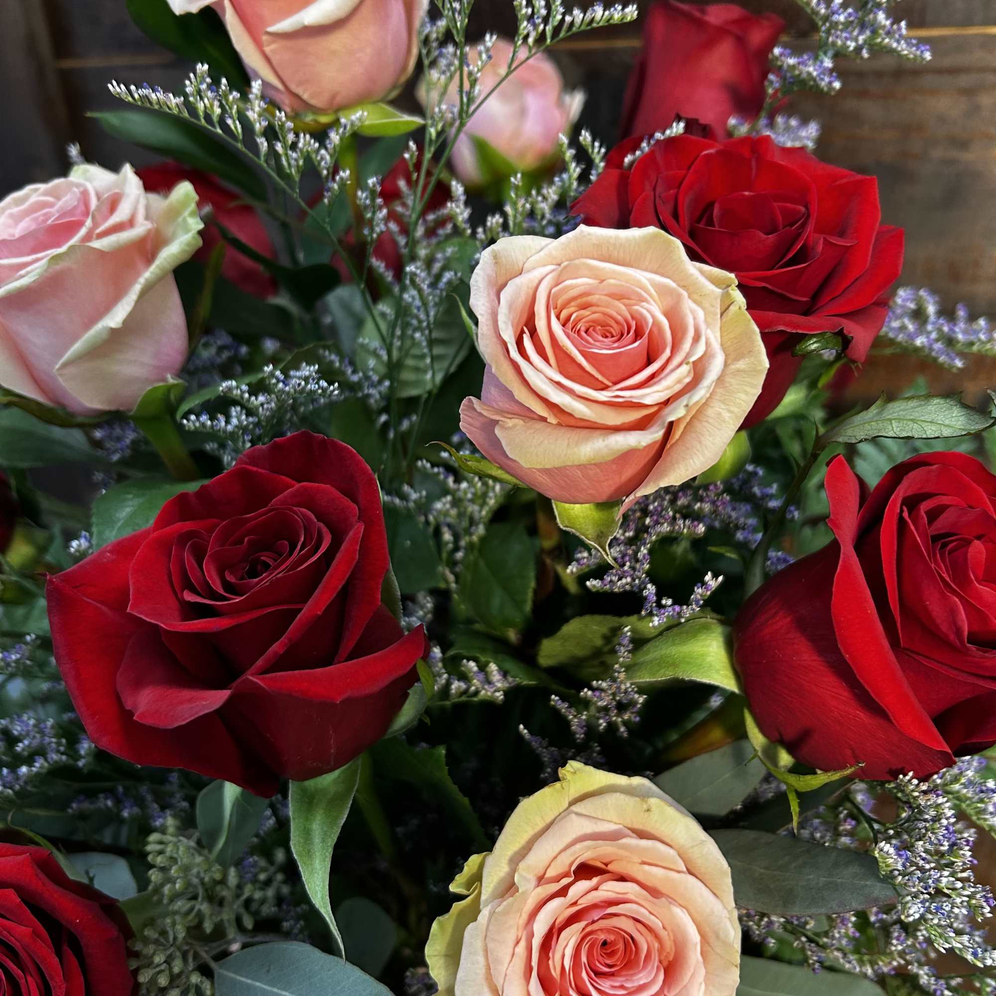 Bouquet of red and blush roses with small purple filler flowers